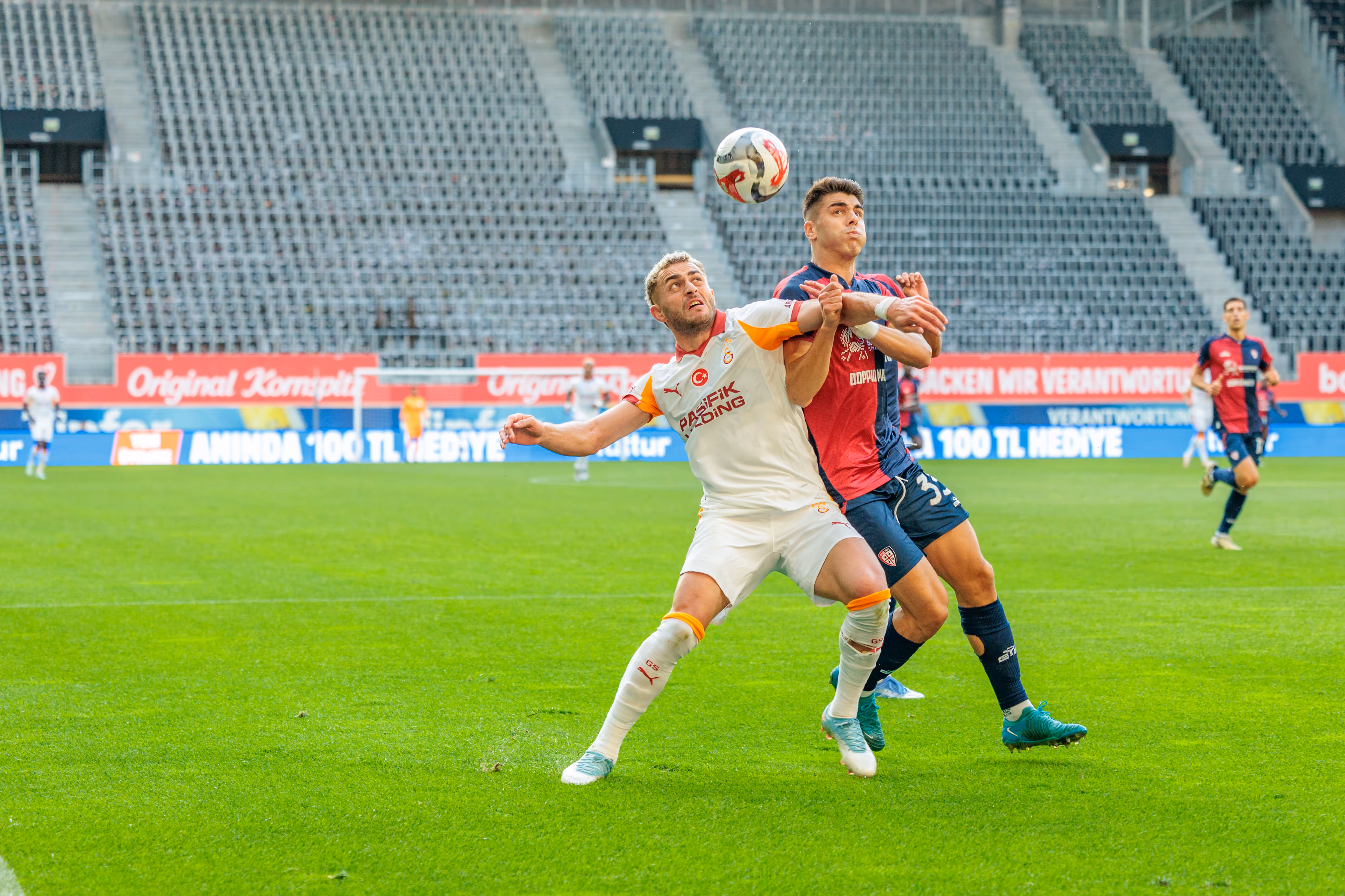Zwei Fußballspieler köpfen den Ball in einem Kopfballduell während eines Vorbereitungsspiels vor leeren Rängen