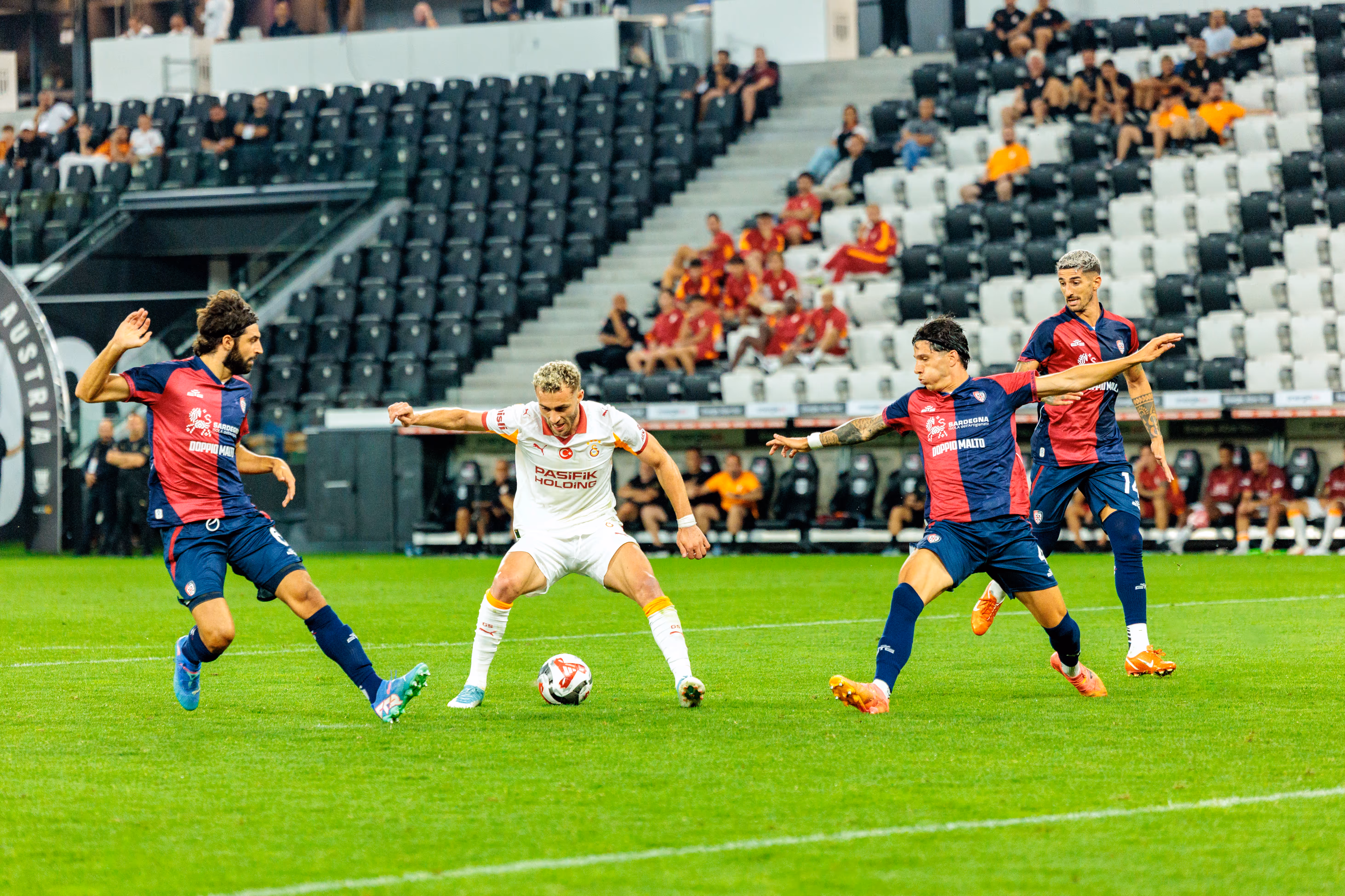 Drei Fußballspieler von Cagliari und Galatasaray kämpfen während eines Spiels der Nero Summer Series im Stadion um den Ball
