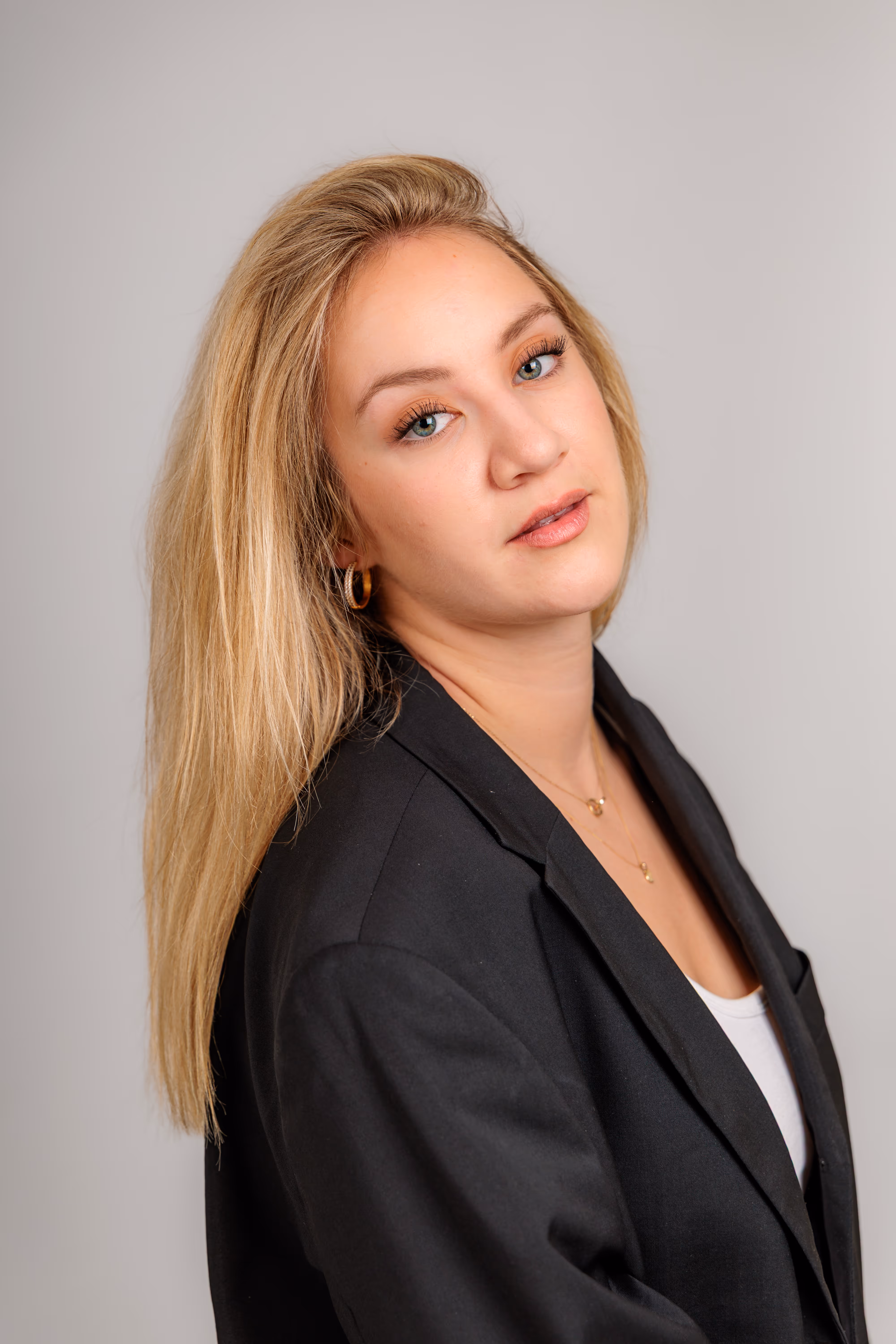 Professionelles Business-Porträt von Model Anna, die in einem schwarzen Blazer mit leicht geneigtem Kopf in die Kamera blickt