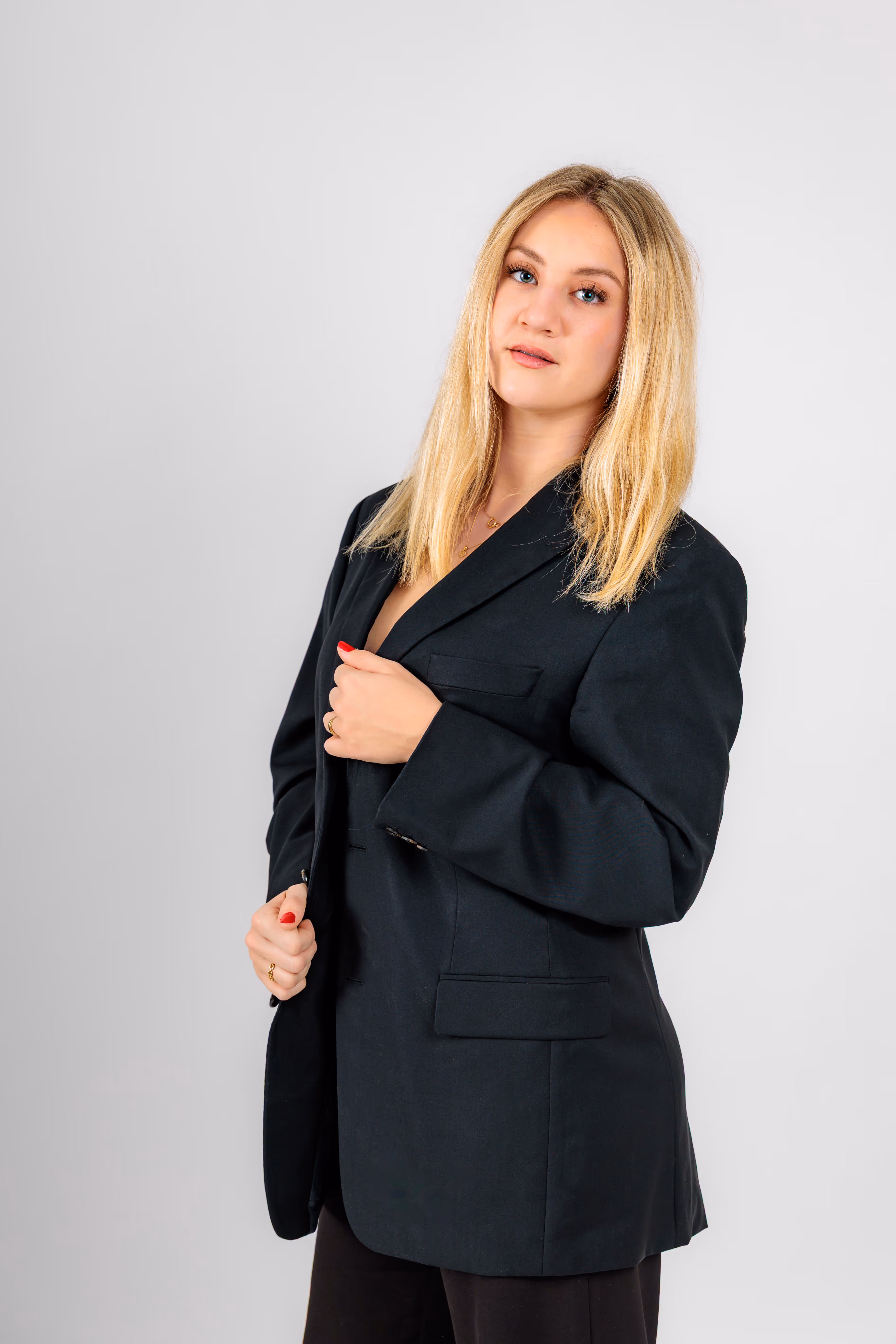 Model Anna posiert selbstbewusst in einem schwarzen Business-Sakko und blickt dabei direkt in die Kamera