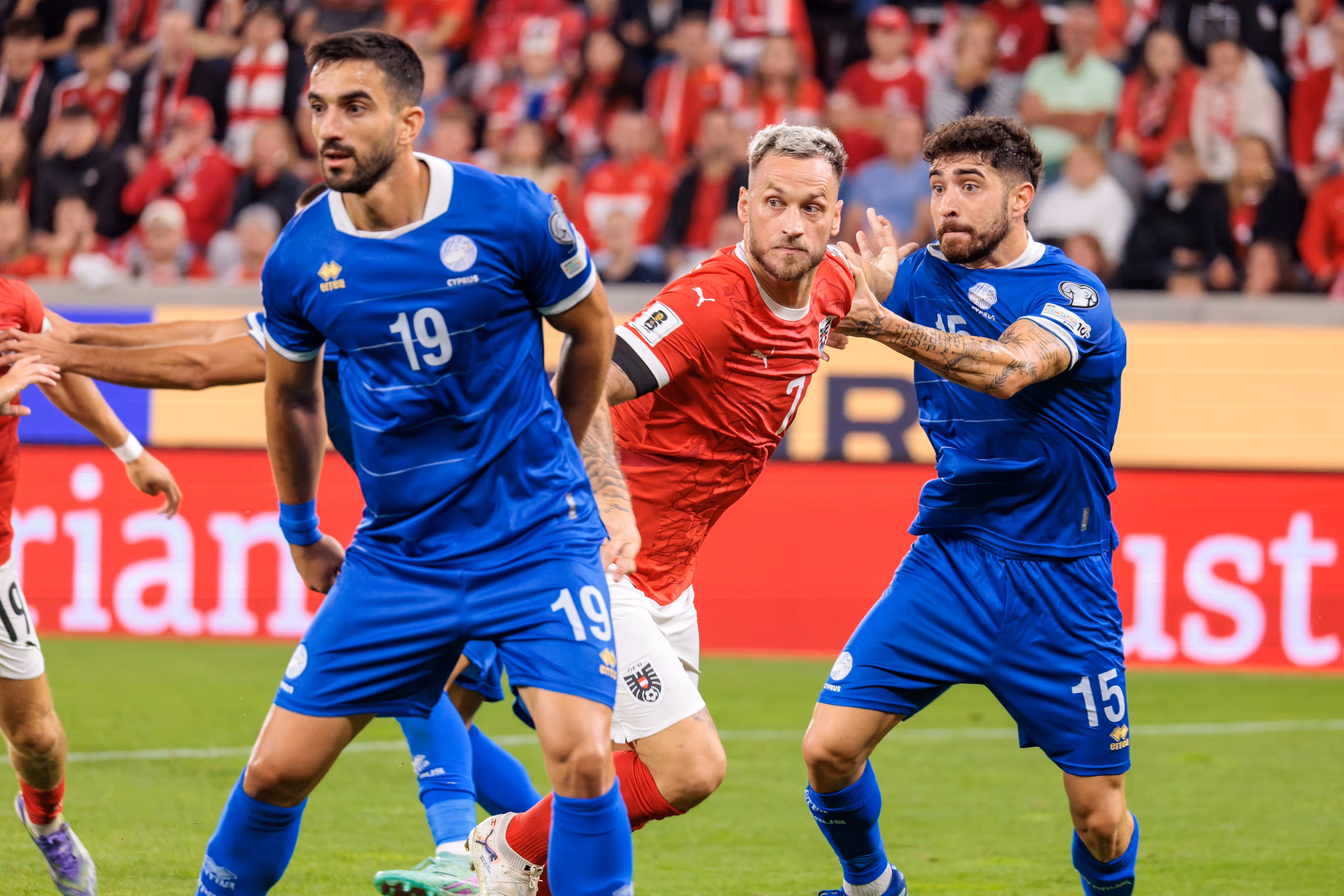 Marko Arnautović im roten Trikot im Zweikampf mit zwei zyprischen Fußballern in blauen Trikots während des WM-Qualifikationsspiels Österreich gegen Zypern