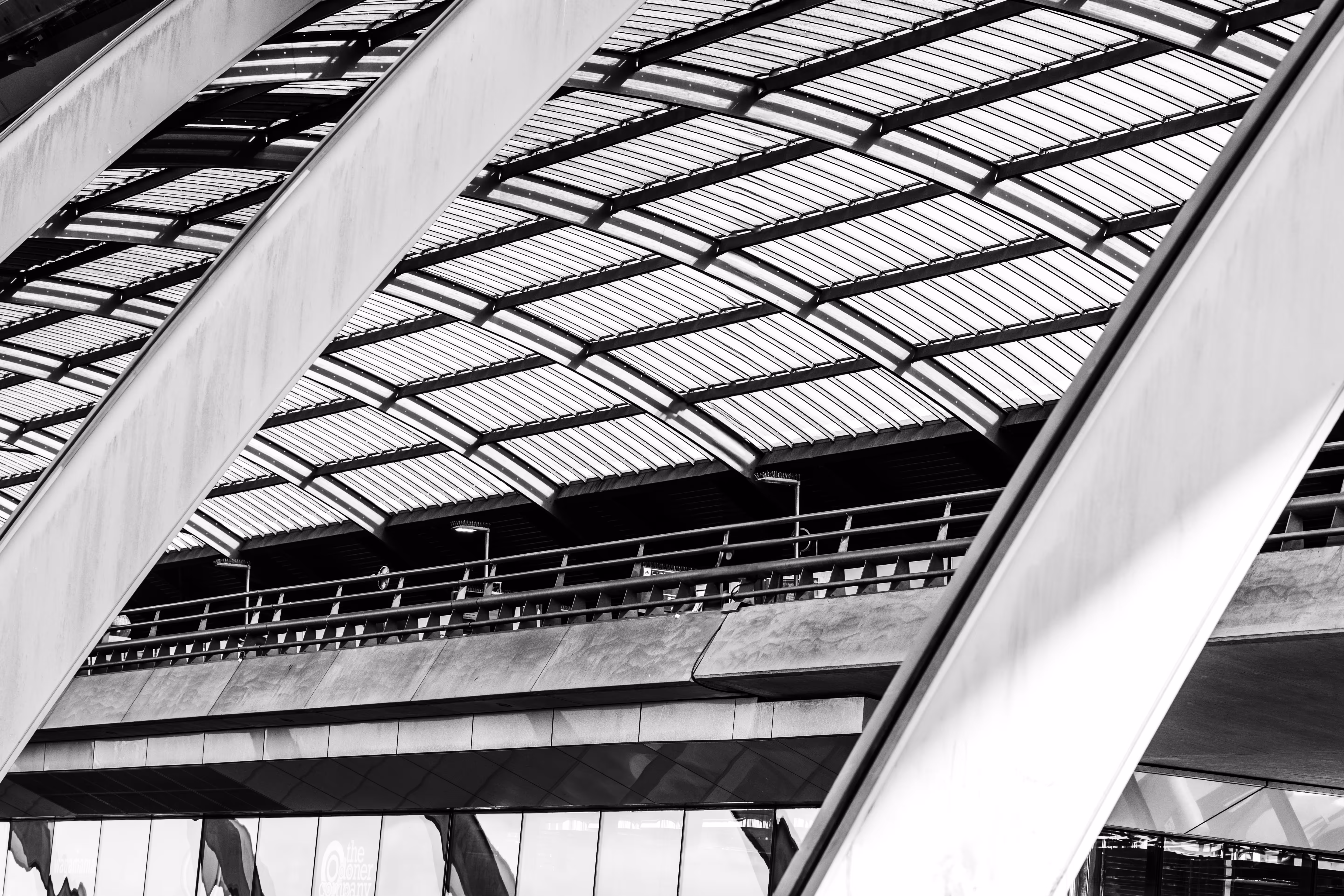 Schwarz-Weiß-Abstraktion der Architektur des Amsterdamer Hauptbahnhofs mit markanten diagonalen Linien und einem strukturierten Glasdach 