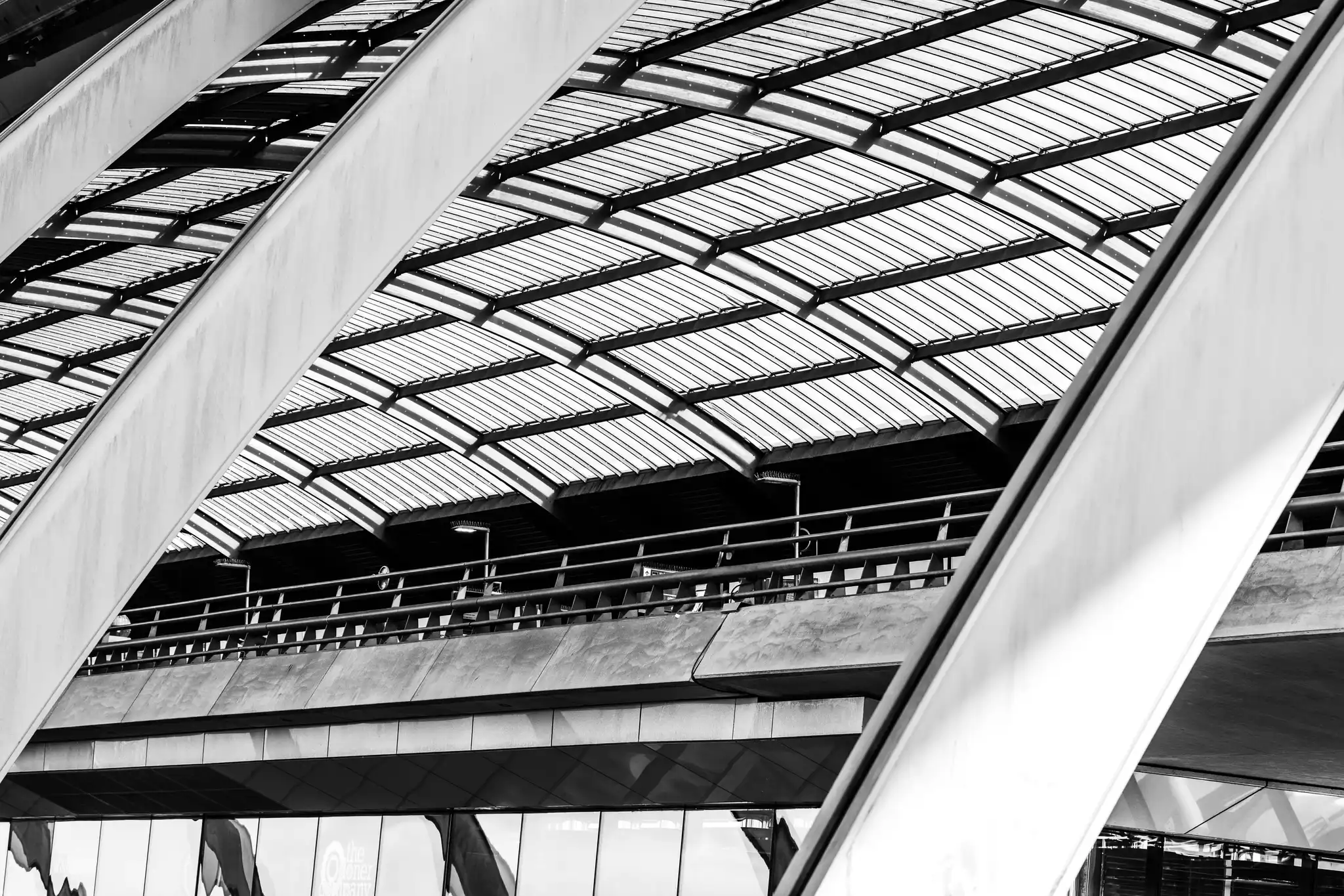 Schwarz-Weiß-Abstraktion der Architektur des Amsterdamer Hauptbahnhofs mit markanten diagonalen Linien und einem strukturierten Glasdach