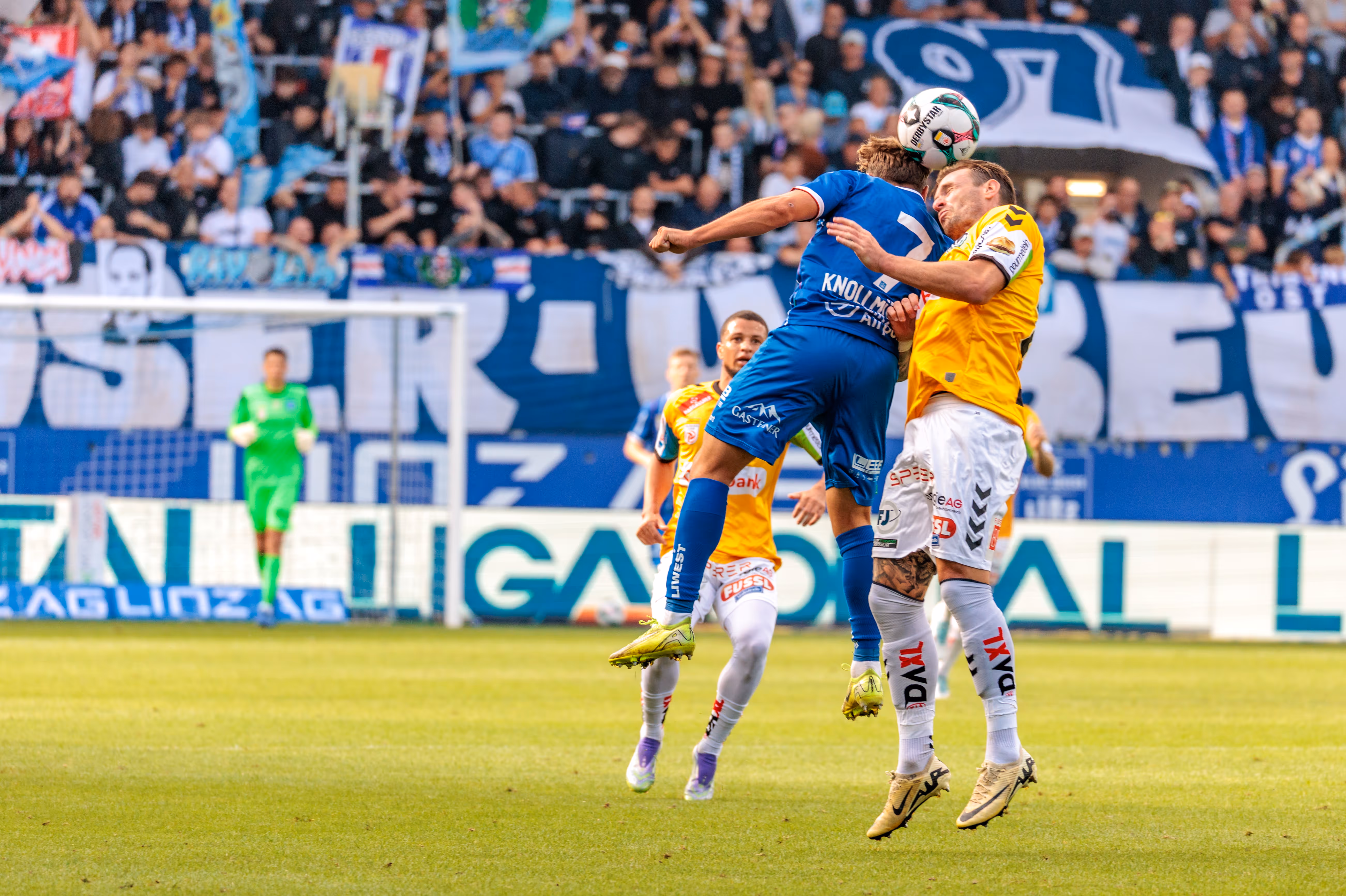 Zwei Spieler von Blau-Weiß Linz und SV Ried im entscheidenden Kopfballduell um den Ball während einer Bundesliga-Partie