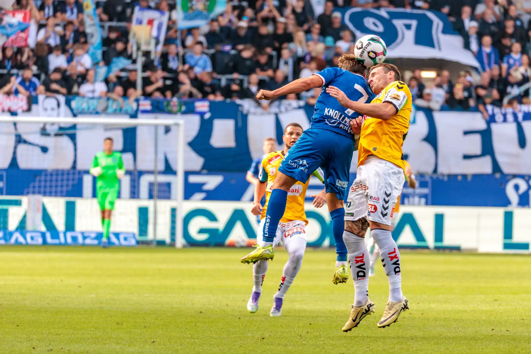 Zwei Spieler von Blau-Weiß Linz und SV Ried im entscheidenden Kopfballduell um den Ball während einer Bundesliga-Partie