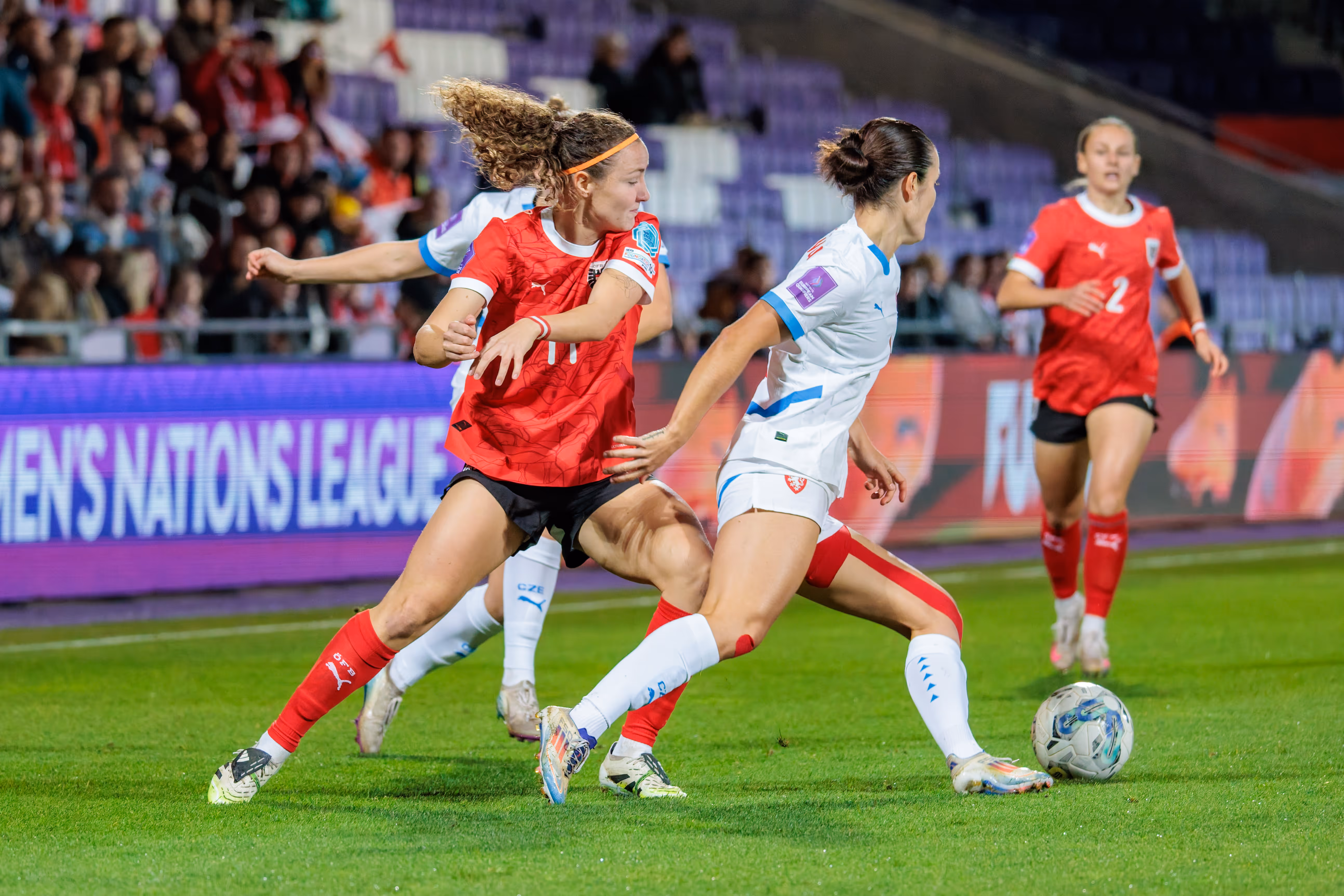 Die österreichische Nationalspielerin Eileen Campbell dribbelt im roten Trikot in einem Zweikampf gegen eine tschechische Gegenspielerin