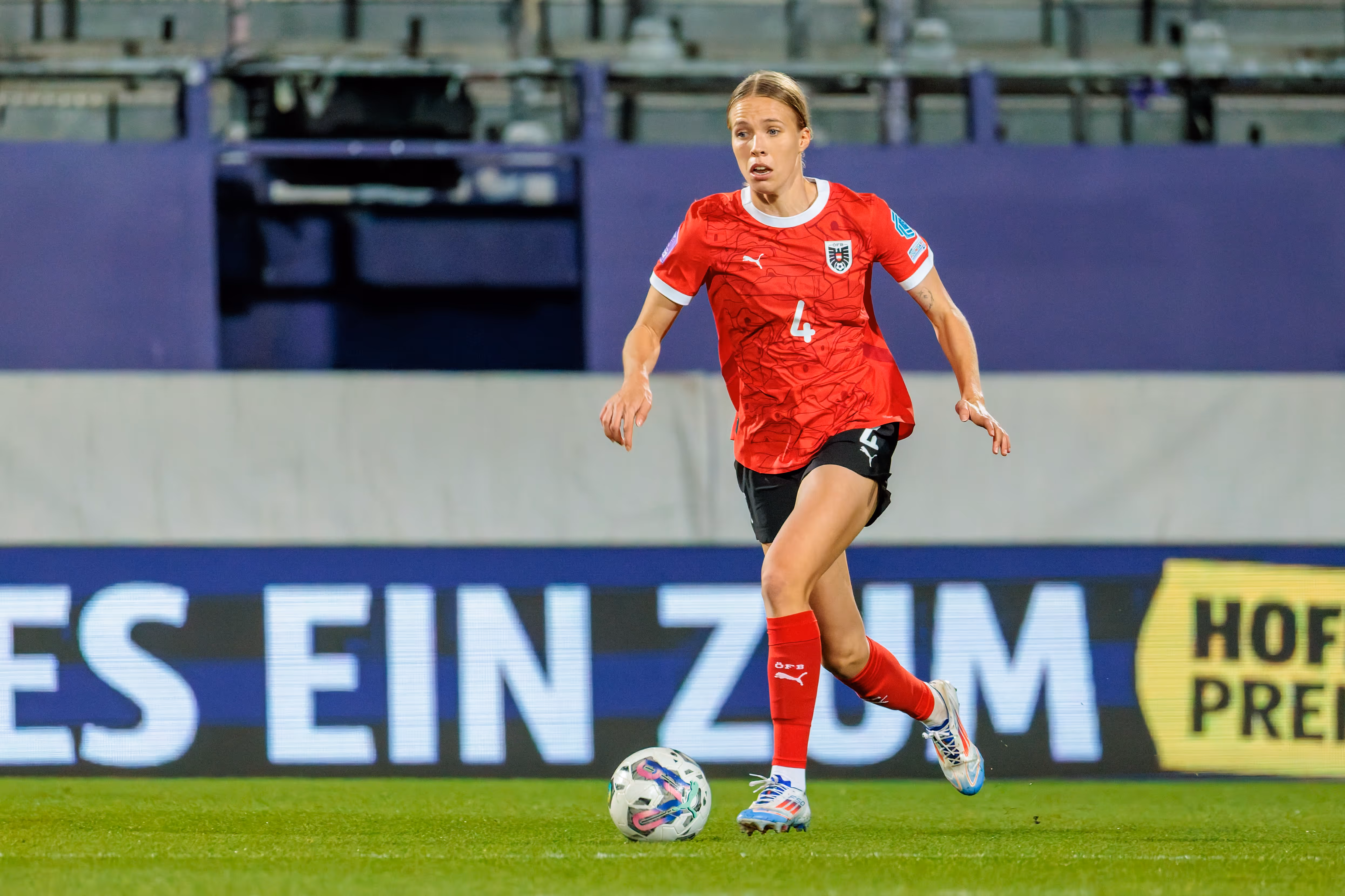 ÖFB-Nationalspielerin Celina Degen führt im roten Trikot mit der Nummer 4 konzentriert den Ball am Fuß