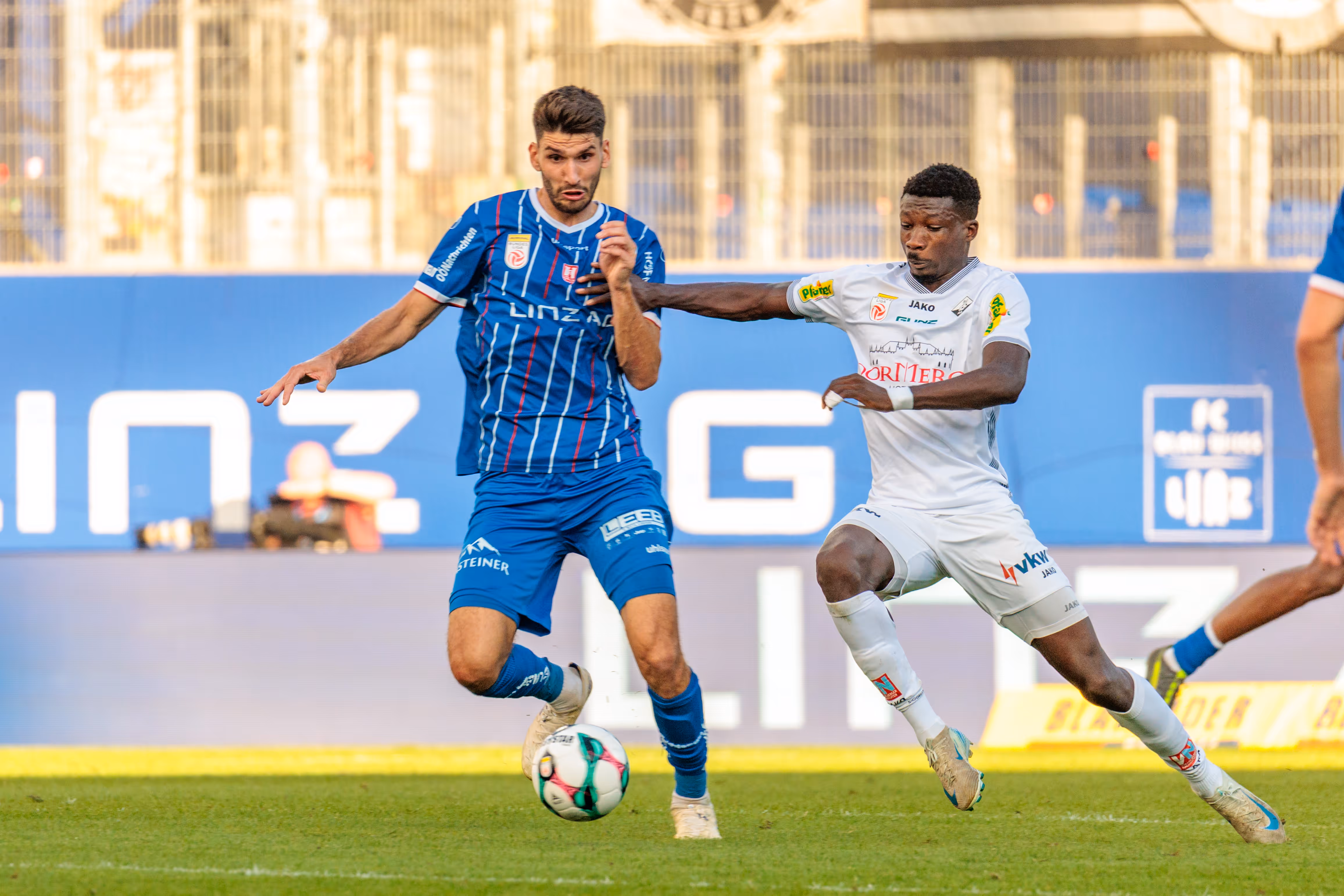 Christopher Cvetko vom FC Blau-Weiß Linz führt den Ball am Fuß und wird im intensiven Zweikampf von Mohamed Ouedraogo vom SCR Altach bedrängt