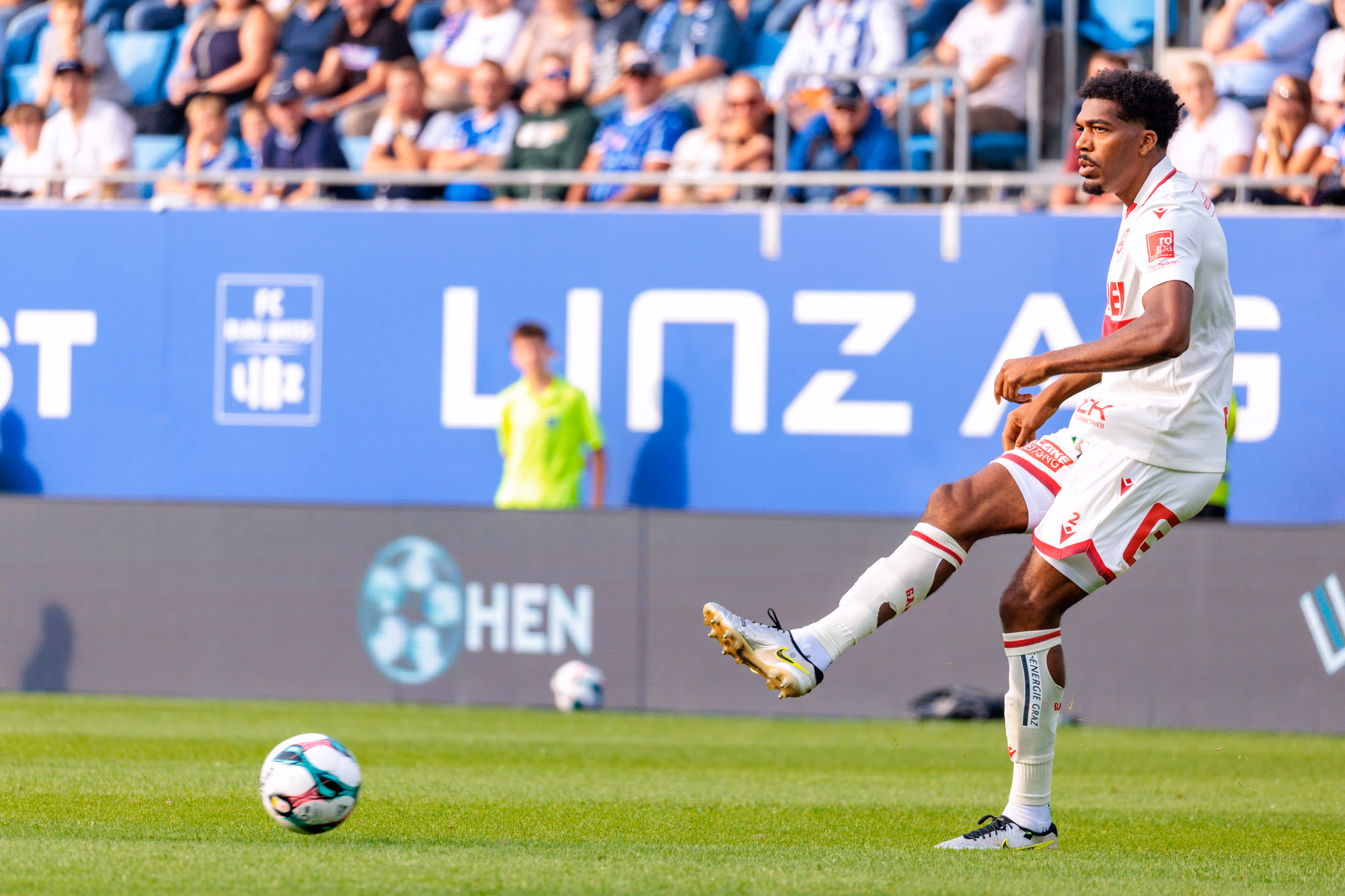 Fußballspieler Donovan Pines vom Grazer AK schlägt in seinem weißen Trikot während eines Bundesliga-Spiels einen Pass