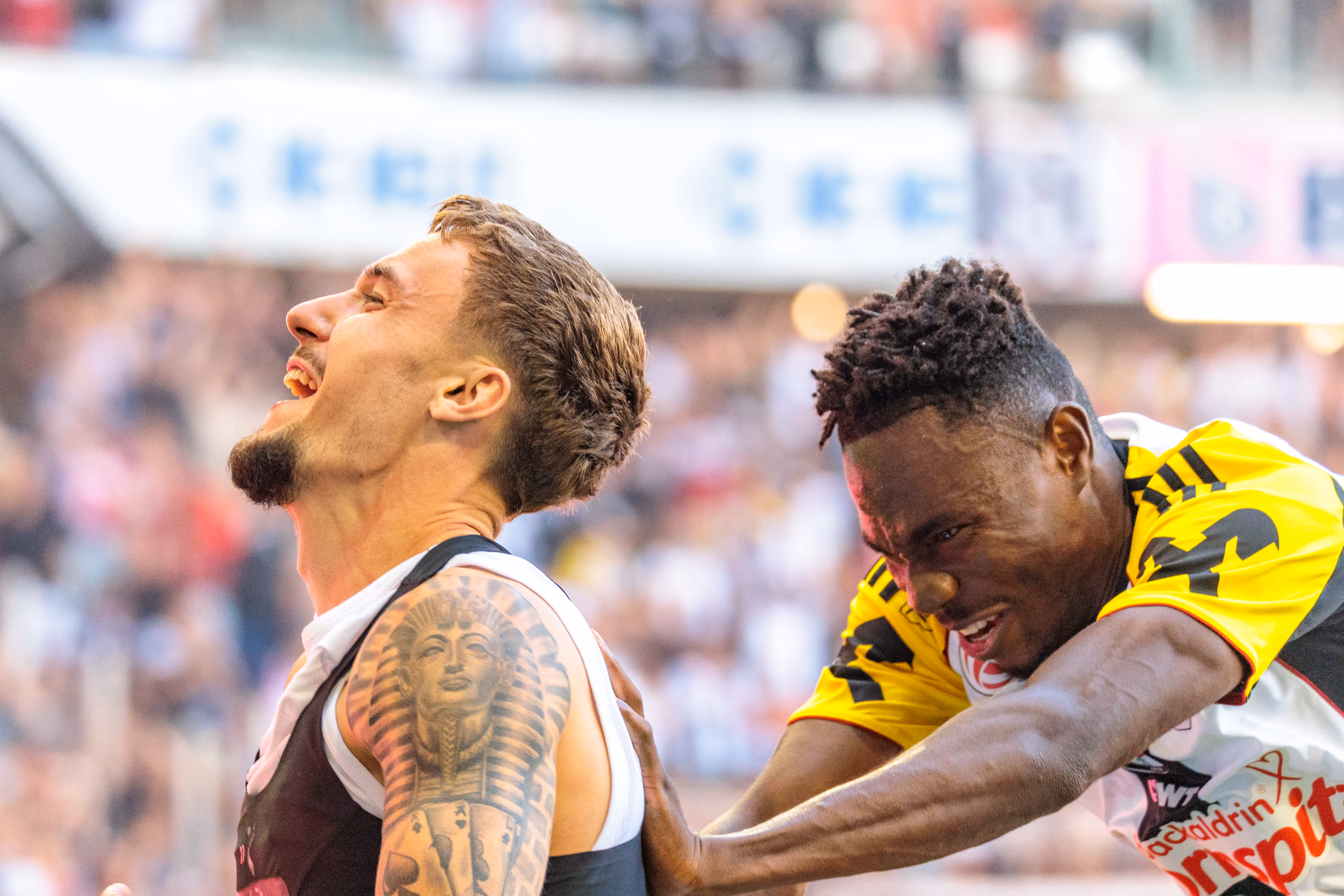 LASK-Stürmer Maximilian Entrup jubelt voller Emotionen mit zurückgelegtem Kopf, während sein Teamkollege Moses Usor ihn von hinten umarmt
