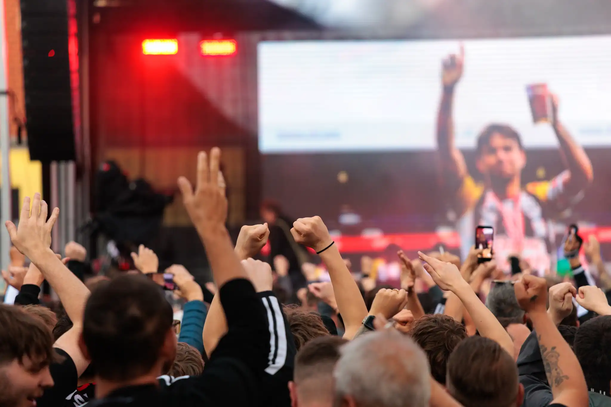 Begeisterte LASK-Fans blicken während der Meisterfeier auf eine große Leinwand mit einer Foto-Diashow und warten auf die Ankunft der Mannschaft