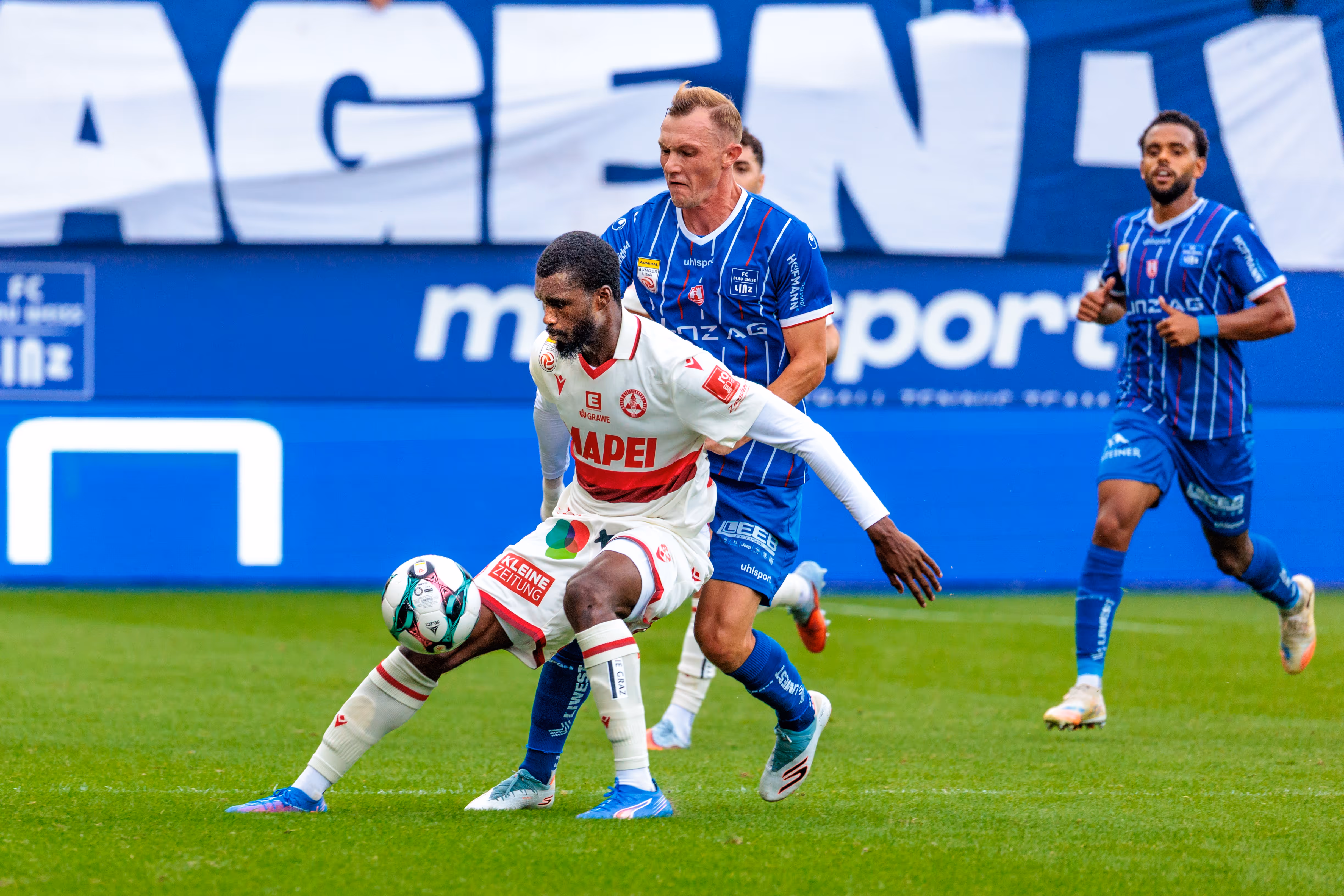Sadik Fofana vom Grazer AK dribbelt den Ball unter Druck von Thomas Goiginger (FC Blau-Weiß Linz) in einem Bundesliga-Spiel