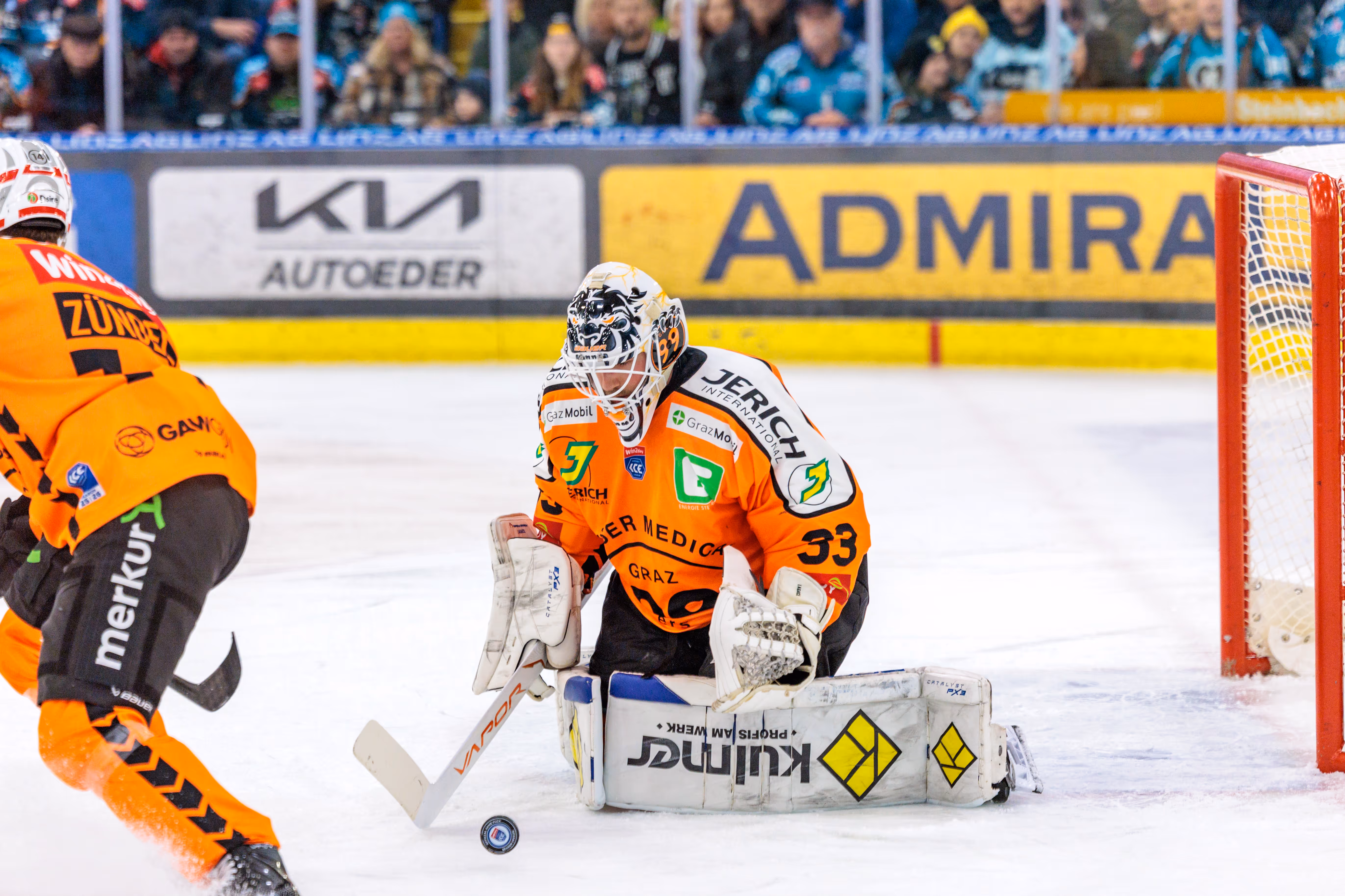 Der Torhüter der Graz99ers, Maxime Legace, kniet in voller Montur vor seinem Tor und beobachtet den Puck, der knapp vor ihm auf dem Eis liegt