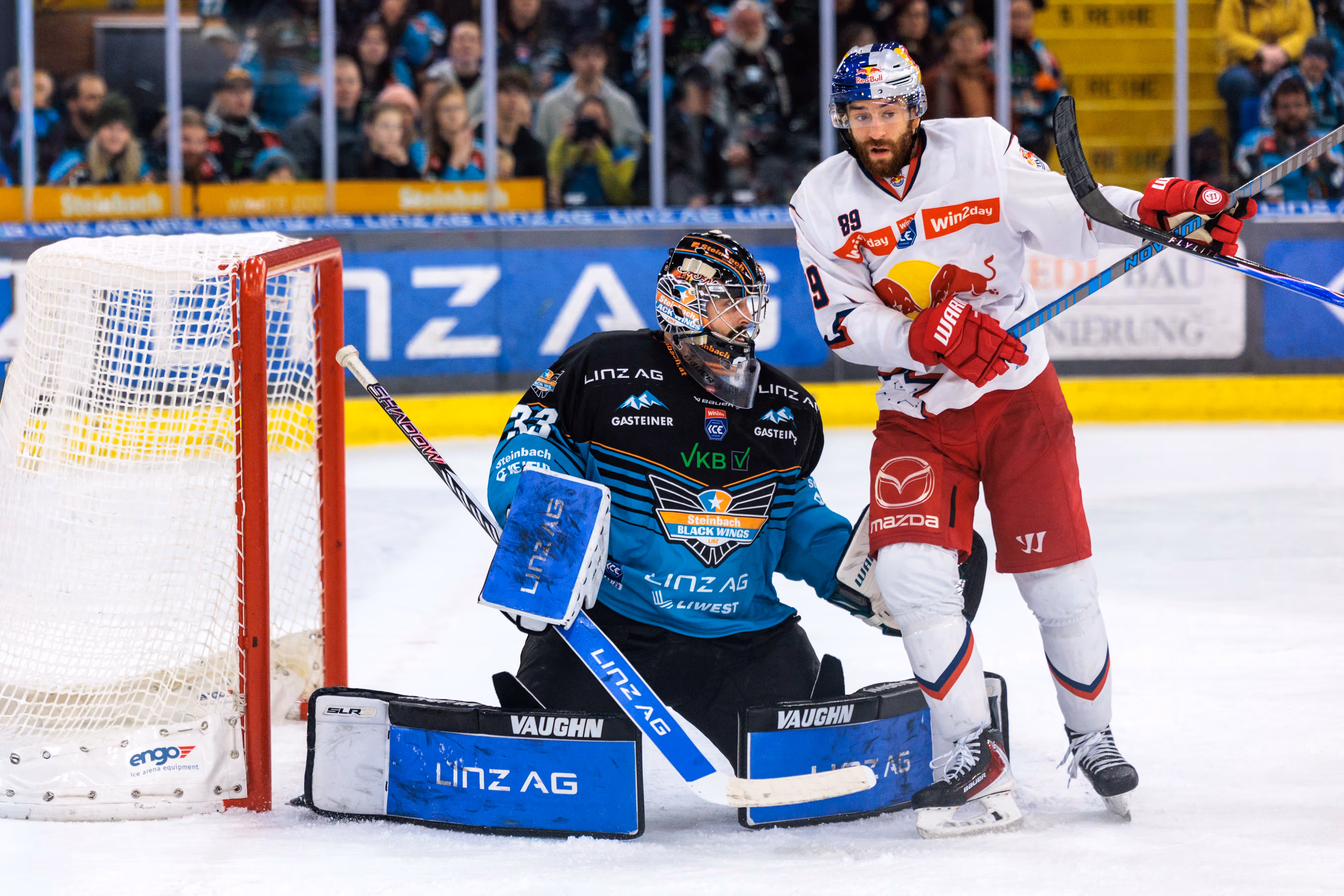 Der Eishockey-Goalie der Steinbach Black Wings Linz, Thomas Höneckl, in einer Spielszene am Tor gegen den Stürmer Florian Baltram vom EC Red Bull Salzburg