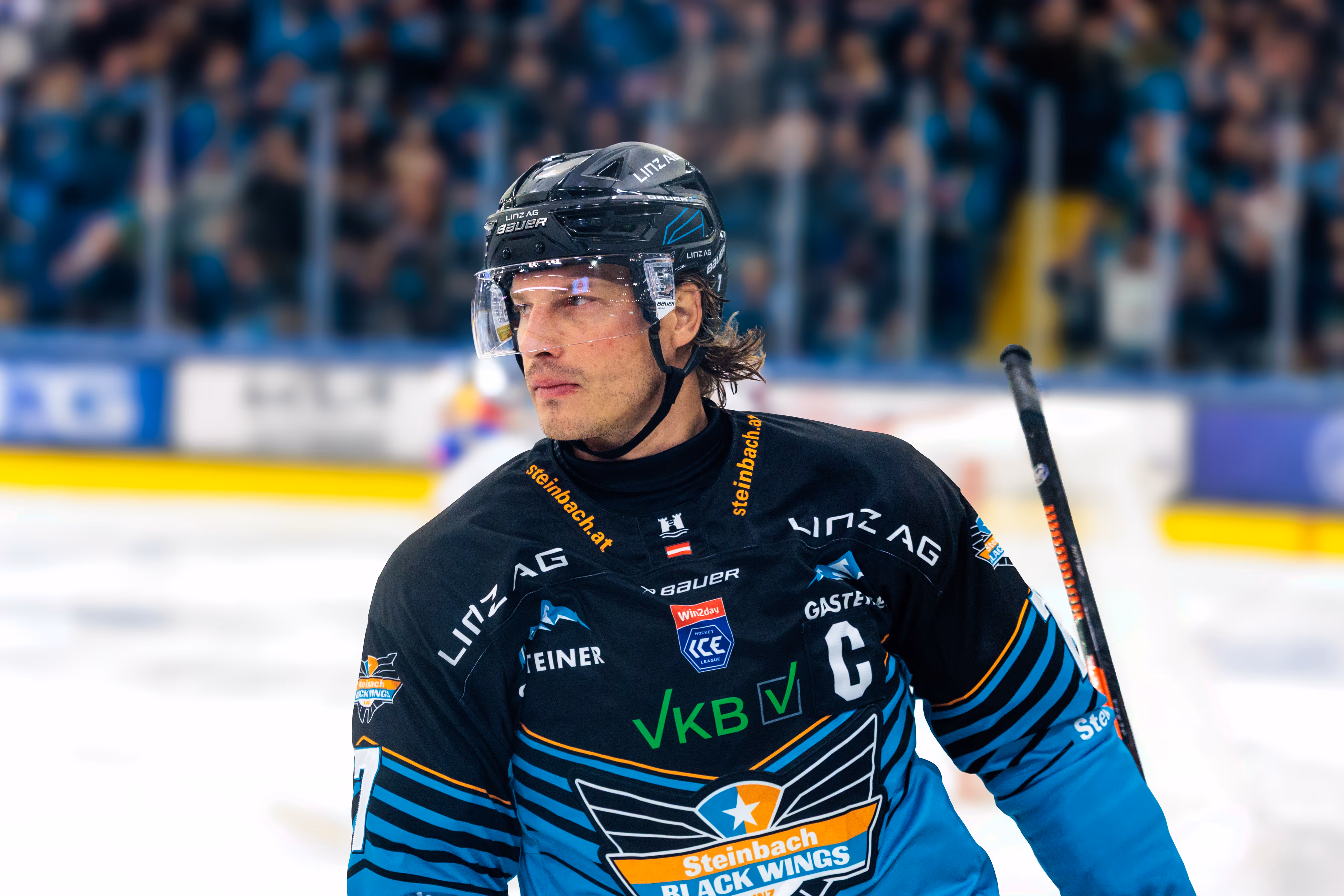 Der Kapitän der Steinbach Black Wings Linz, Brian Lebler, blickt nach einem Torerfolg während eines Eishockeyspiels konzentriert und entschlossen über das Eis