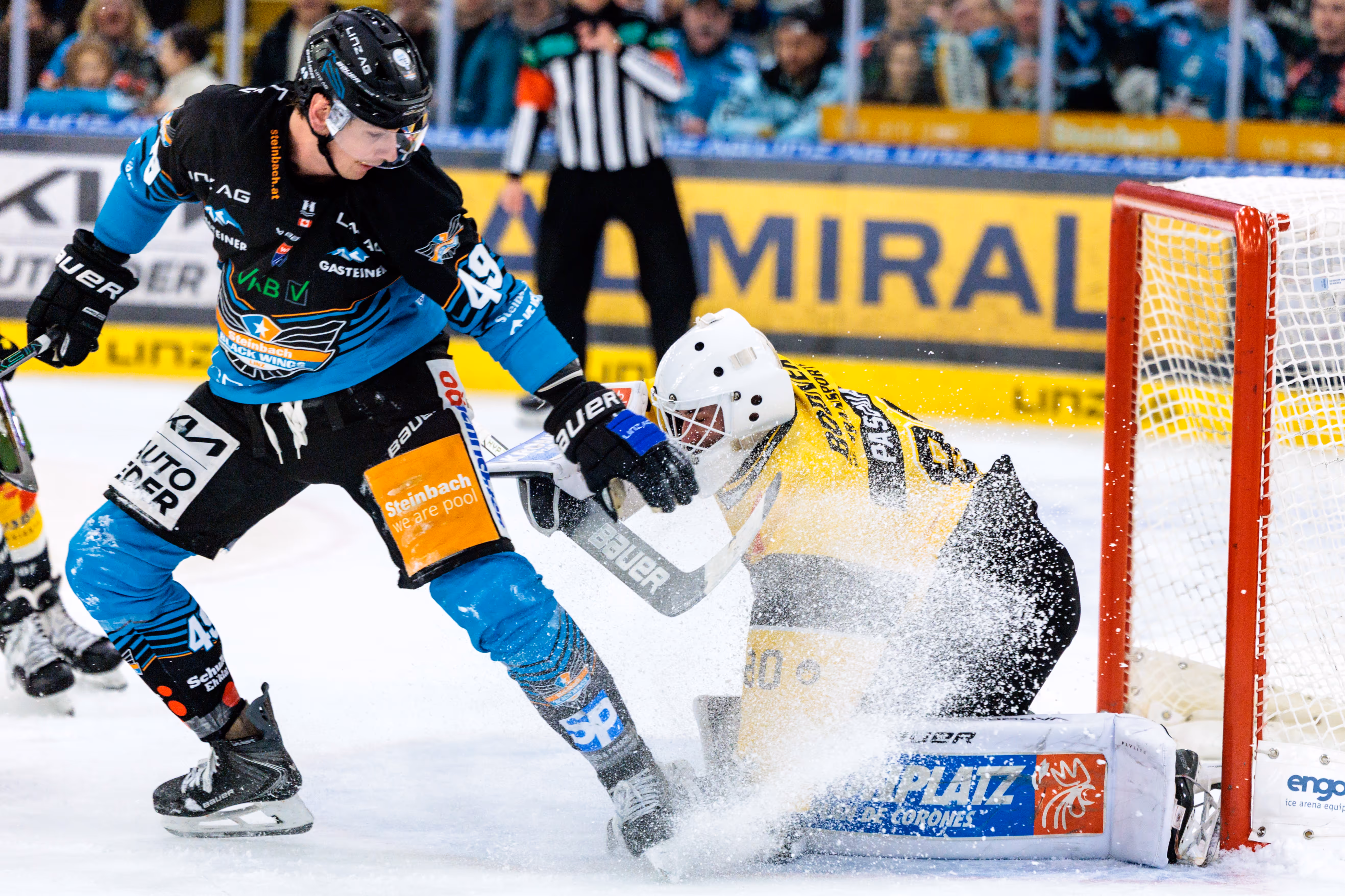 Black Wings Linz-Stürmer Graham Knott versucht den Pustertal-Goalie zu bezwingen und wirbelt dabei eine große Wolke Eis auf