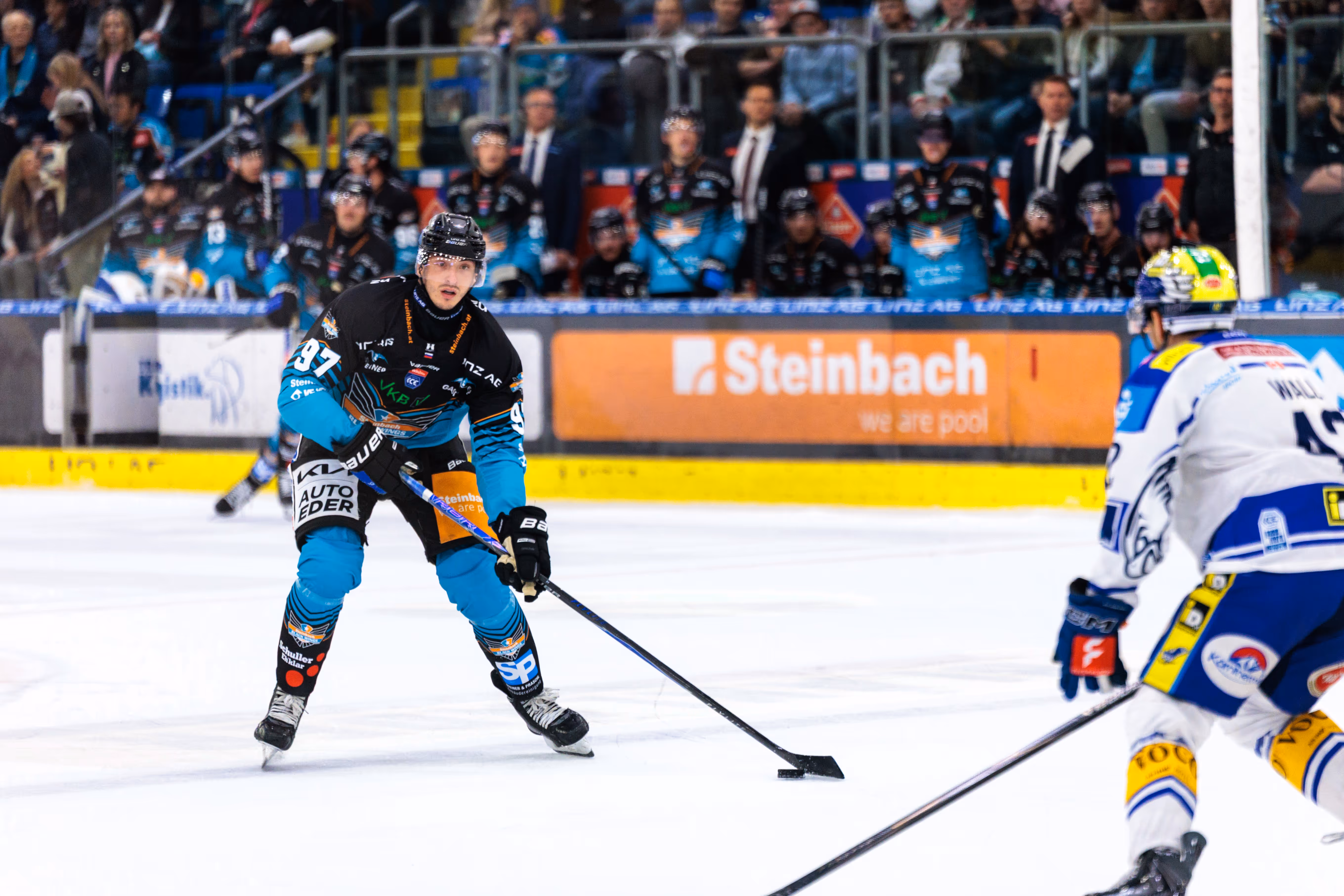 Der Eishockeyspieler Andreas Kristler von den Steinbach Black Wings Linz führt in einer Angriffsposition den Puck am Schläger während des Spiels gegen den EC VSV