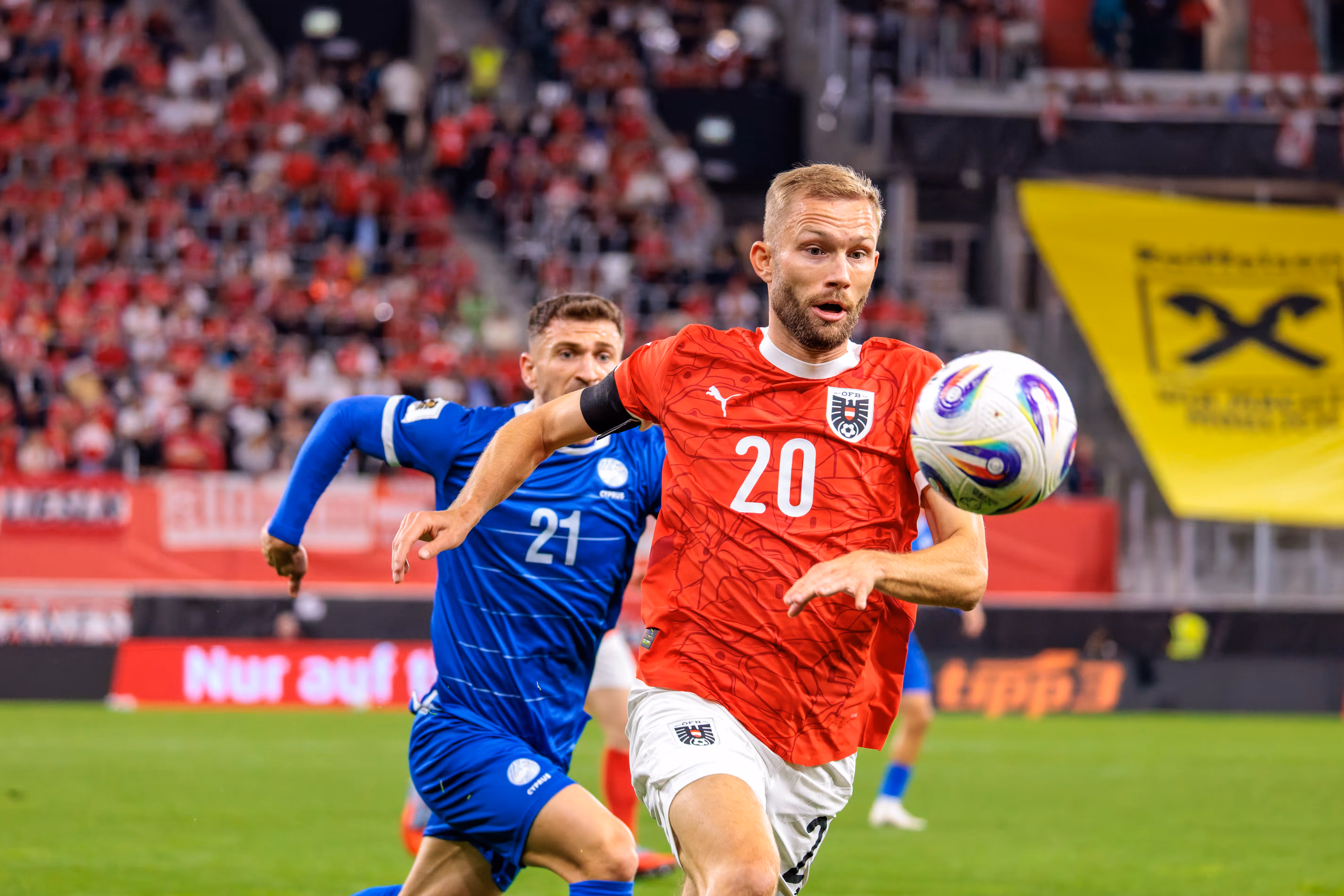 Konrad Laimer, Österreichs Nummer 20, behauptet den Ball im Laufduell gegen Marinos Tzionis, Zyperns Nummer 21, während des Fußballspiels