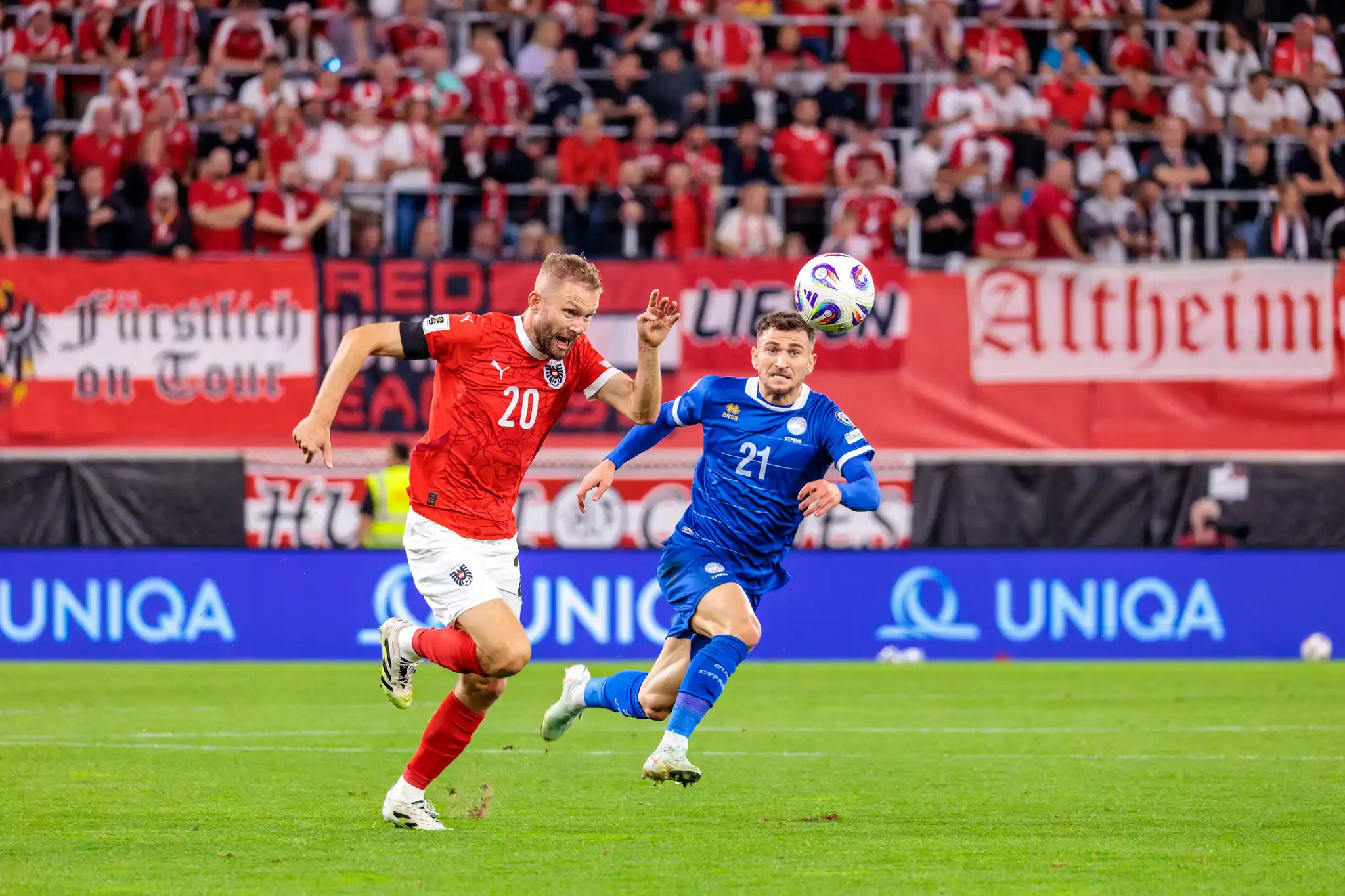 Konrad Laimer im österreichischen Trikot und Marinos Tzionis im zypriotischen Trikot in einem Laufduell um den Ball