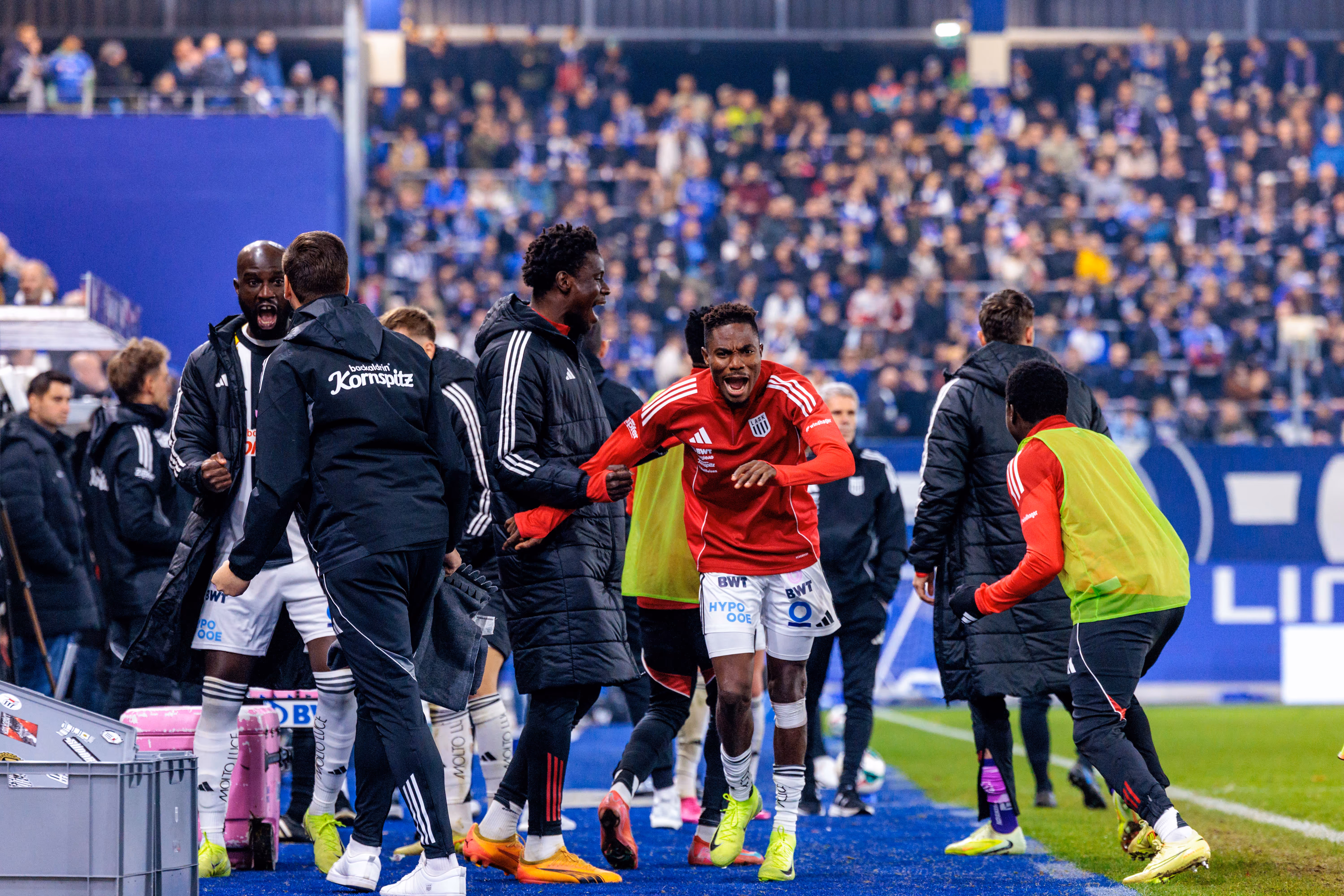 LASK-Stürmer Moses Adeniran feiert sein Tor im Linzer Derby emotional mit den jubelnden Spielern und Betreuern auf der Ersatzbank