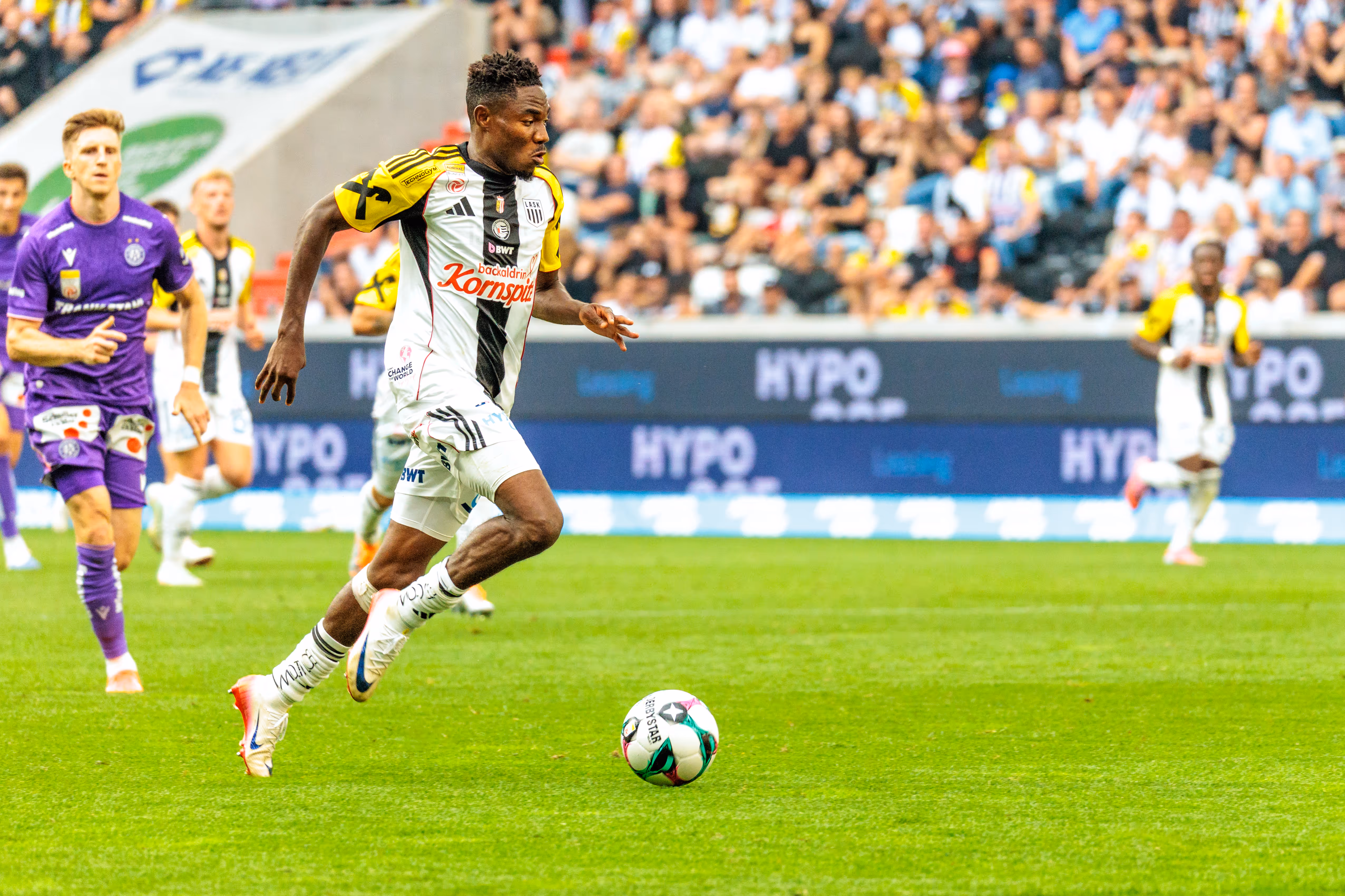 LASK-Spieler Moses Usor dribbelt in einem dynamischen Moment den Ball während eines Bundesliga-Spiels gegen Austria Wien