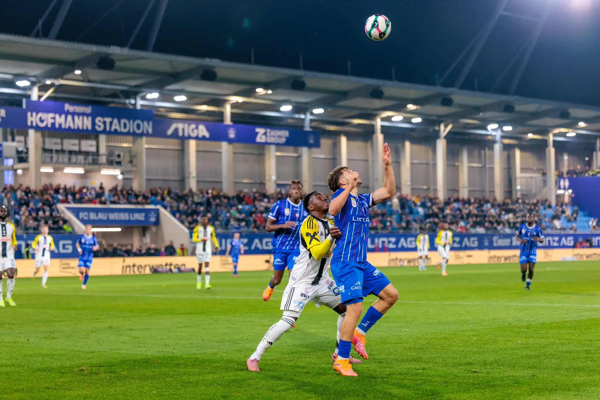 Der Blau-Weiß-Spieler Aleksandar Pašić im intensiven Kopfballduell gegen George Bello vom LASK während des Linzer Derbys in der Bundesliga