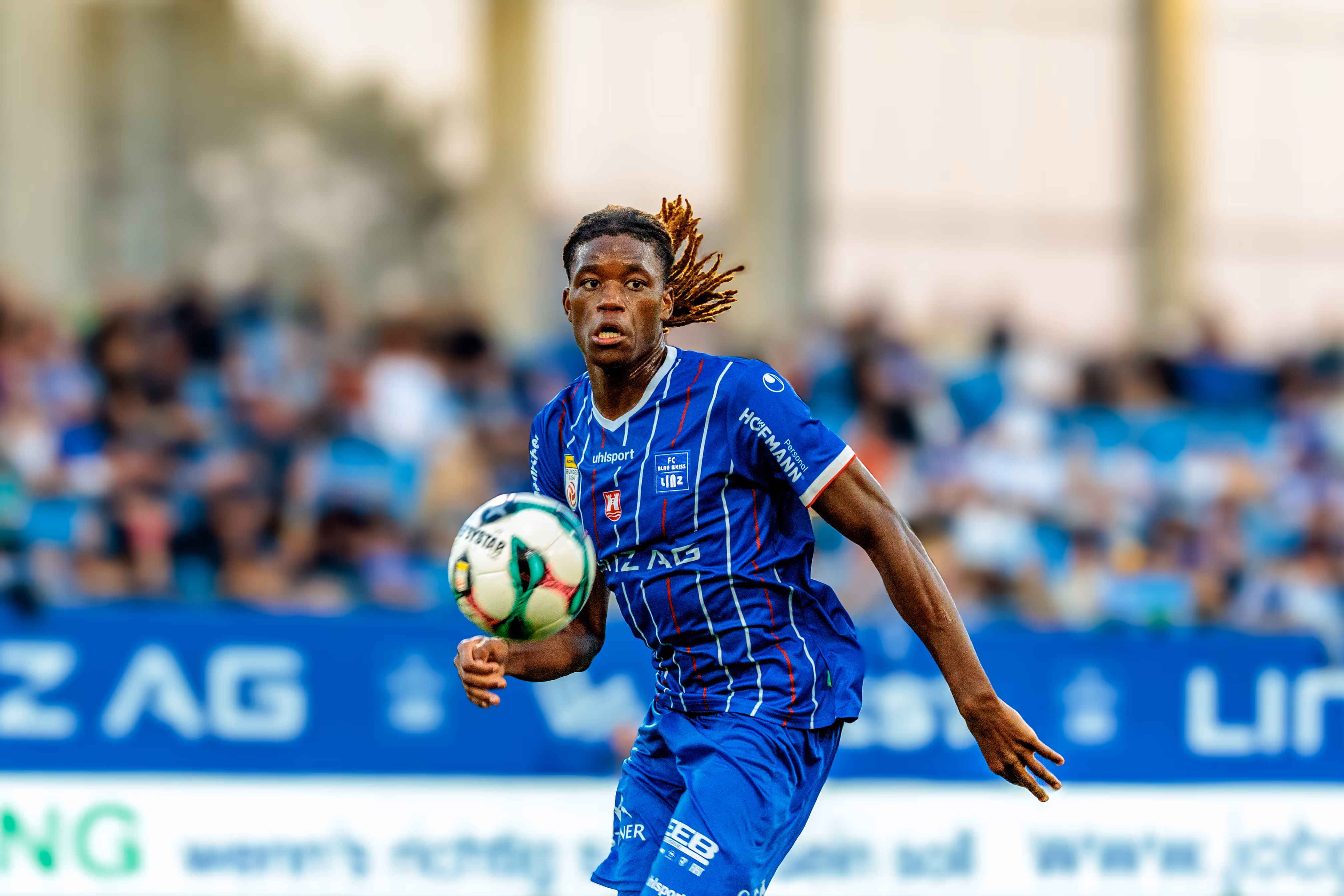 Der Fußballspieler Mamadou Fofana vom FC Blau-Weiß Linz kontrolliert den Ball während des Bundesligaspiels mit konzentriertem Gesichtsausdruck