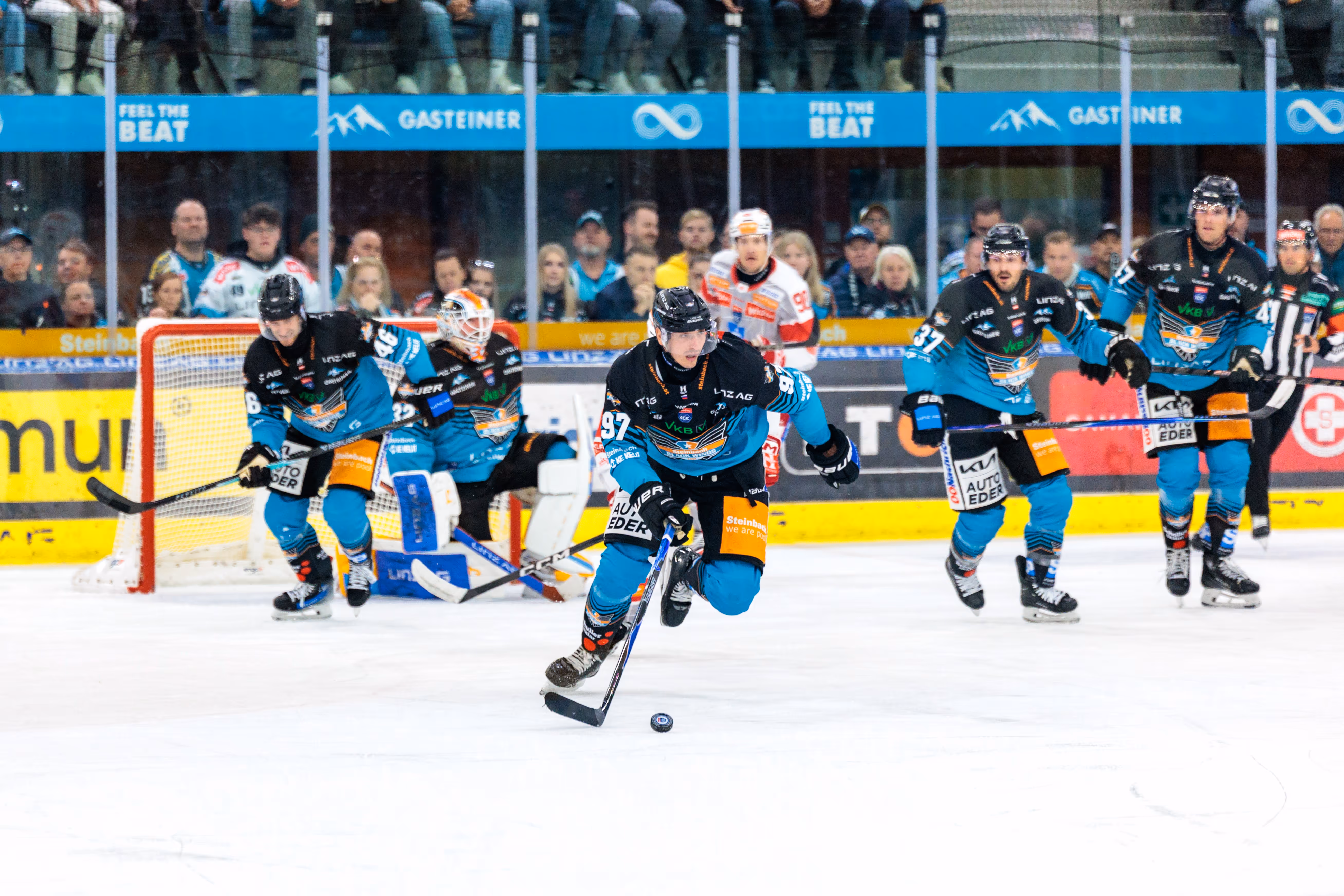Der Stürmer der Steinbach Black Wings Linz, Luka Maver, mit der Nummer 97 führt den Puck im Angriff während eines Eishockeyspiels