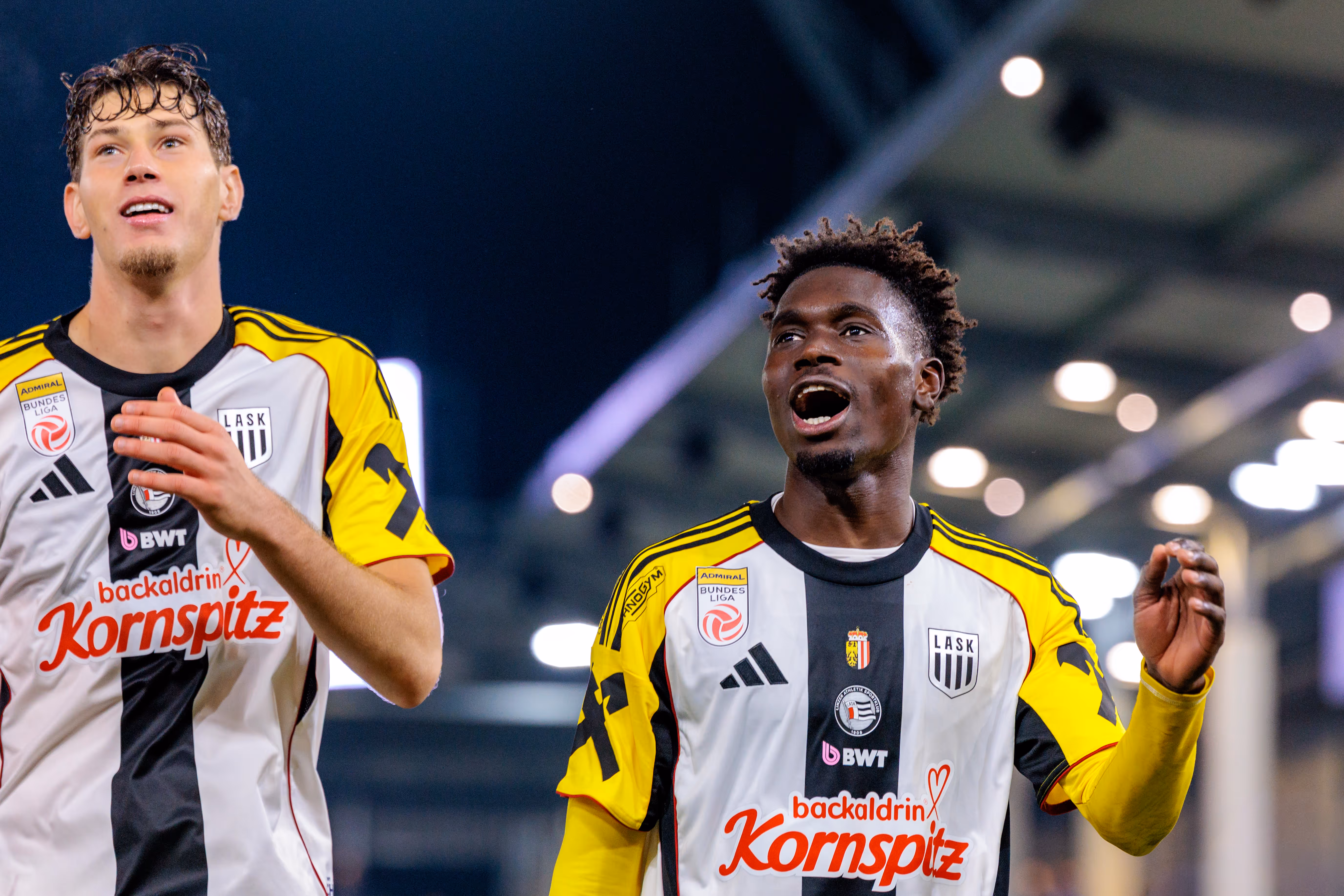 Der LASK-Spieler Modou Keba Cisse feiert mit seinen Teamkollegen laut jubelnd den Derby-Sieg