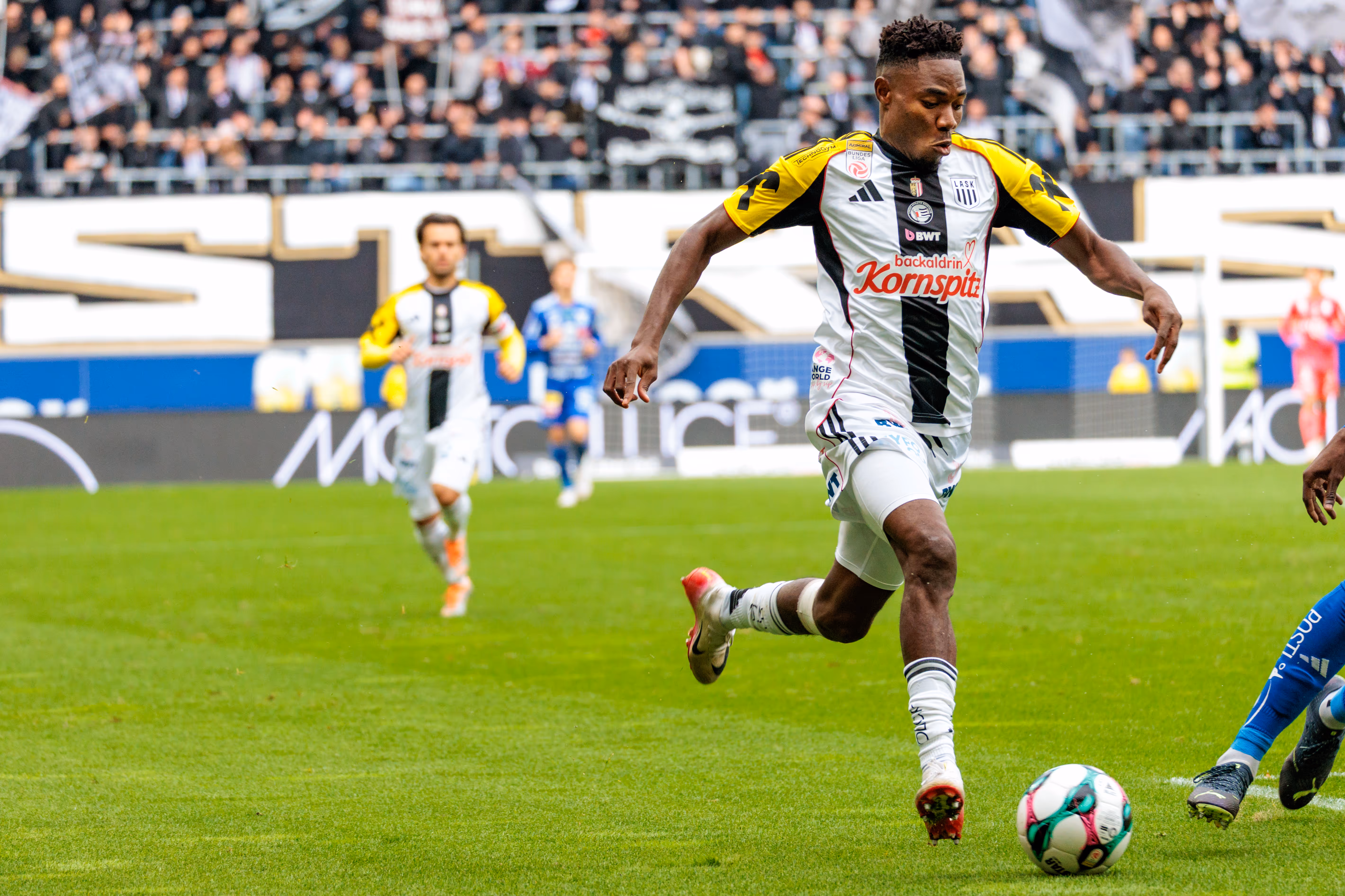LASK-Spieler Moses Usor in einem dynamischen Dribbling mit dem Ball während des Bundesligaspiels gegen den TSV Hartberg