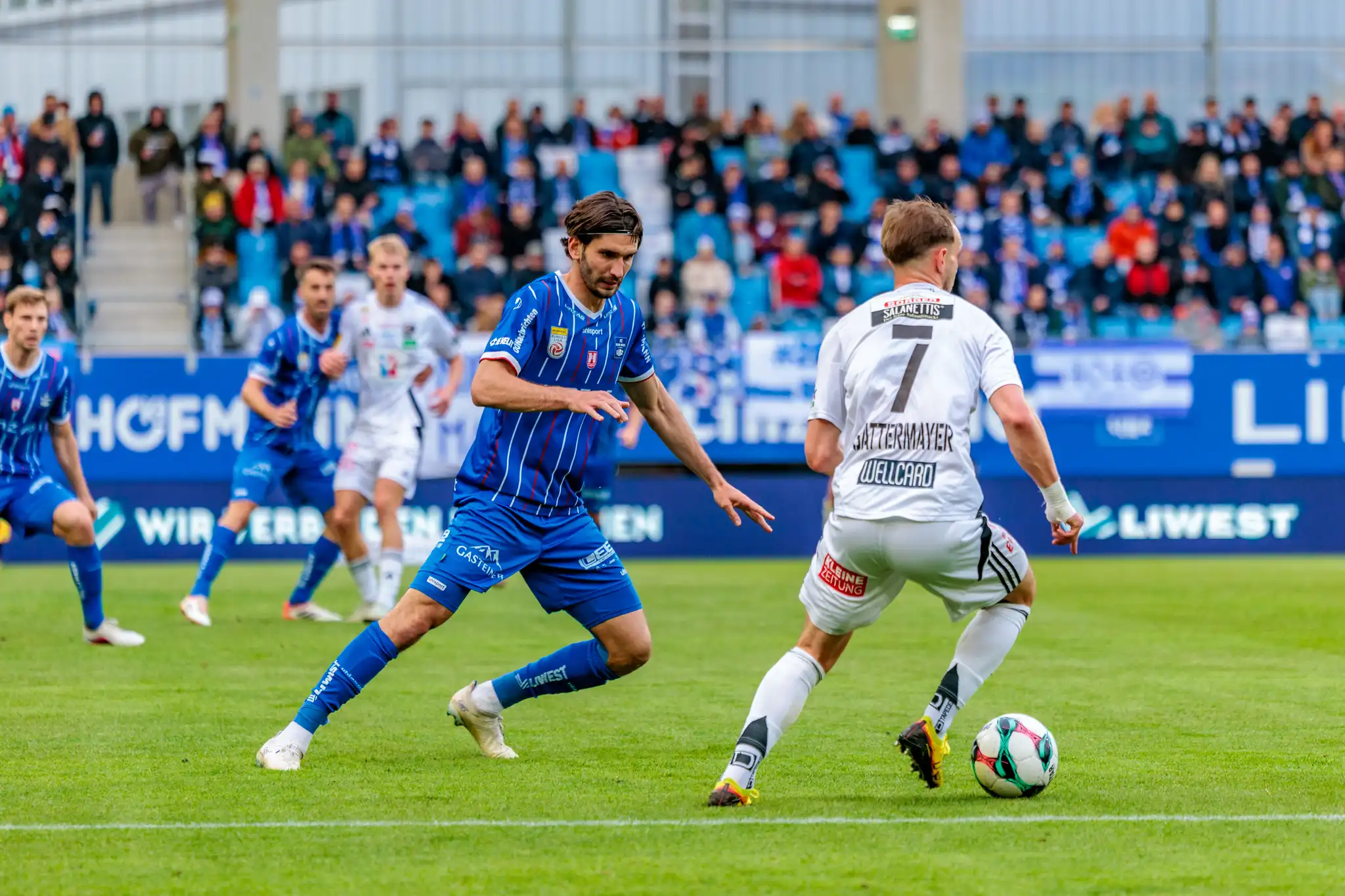 Ein Spieler des Wolfsberger AC führt eine Offensivaktion gegen einen Verteidiger des Blau-Weiß Linz aus