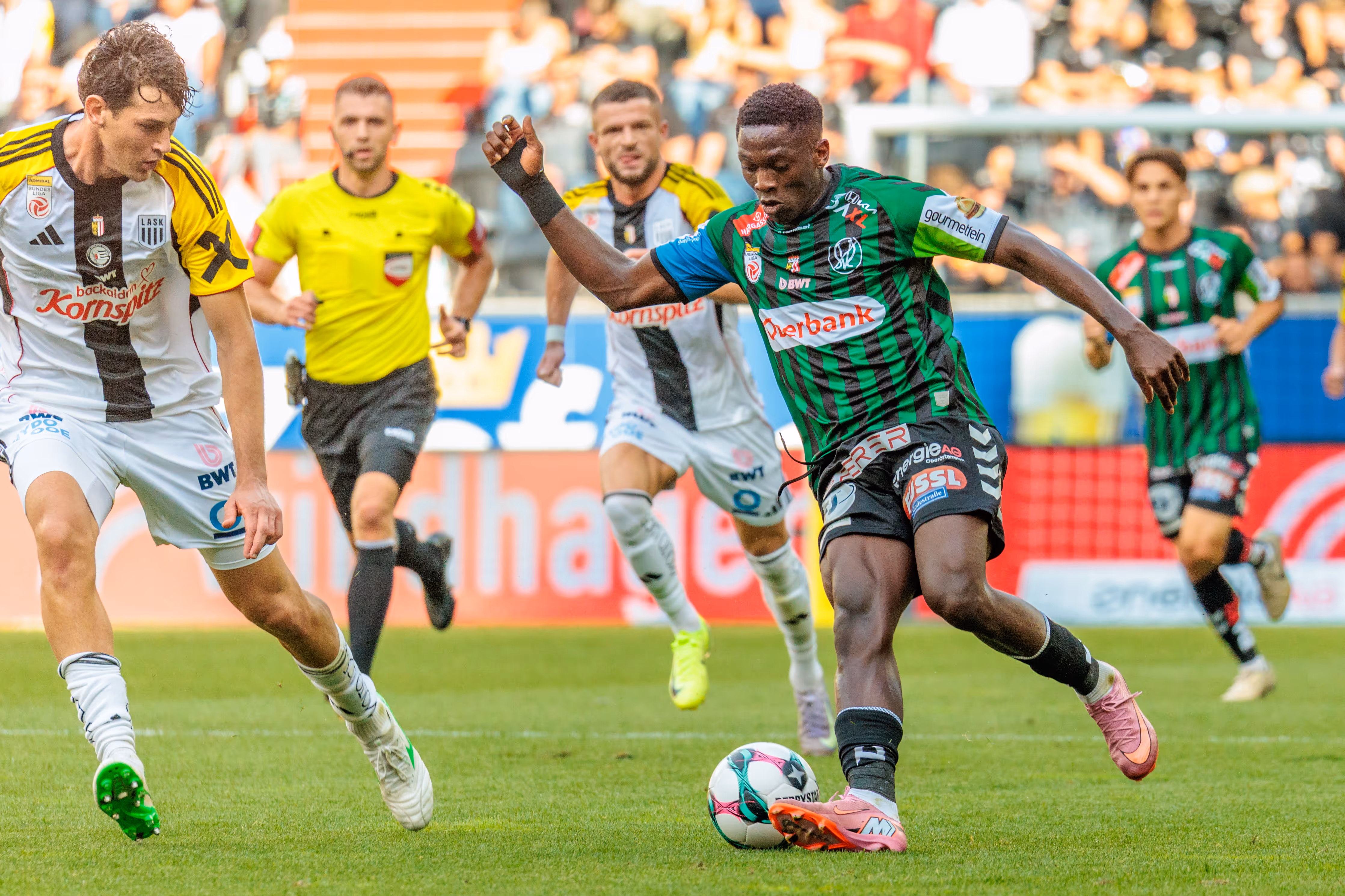 Ein Spieler von SV Ried dribbelt den Ball nach vorne, während ein Spieler des LASK verteidigt, während eines Bundesliga-Fußballspiels
