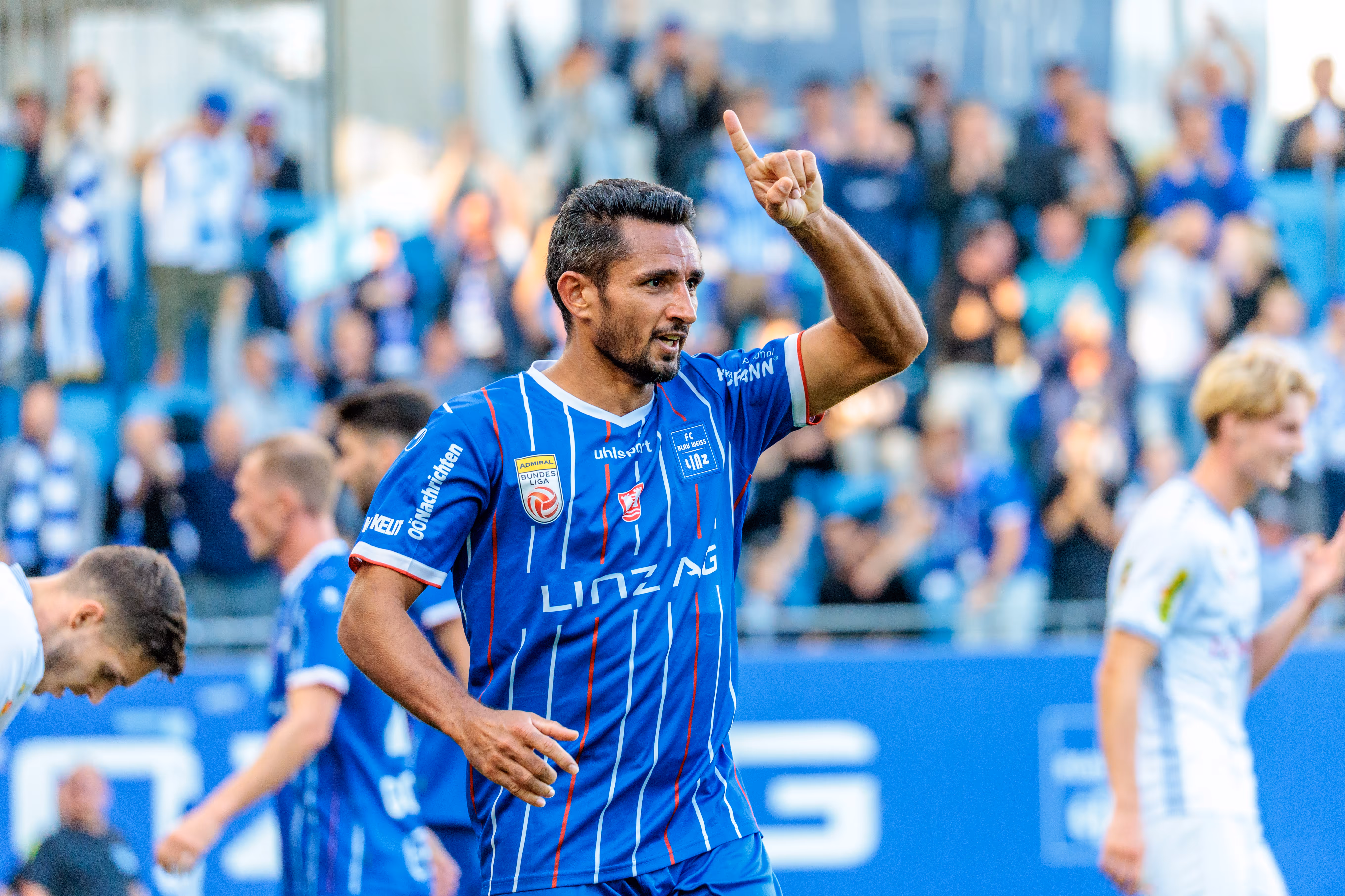 Der Torschütze Ronivaldo vom FC Blau-Weiß Linz jubelt im blau-weiß gestreiften Trikot und reckt nach seinem Tor den Zeigefinger in die Luft