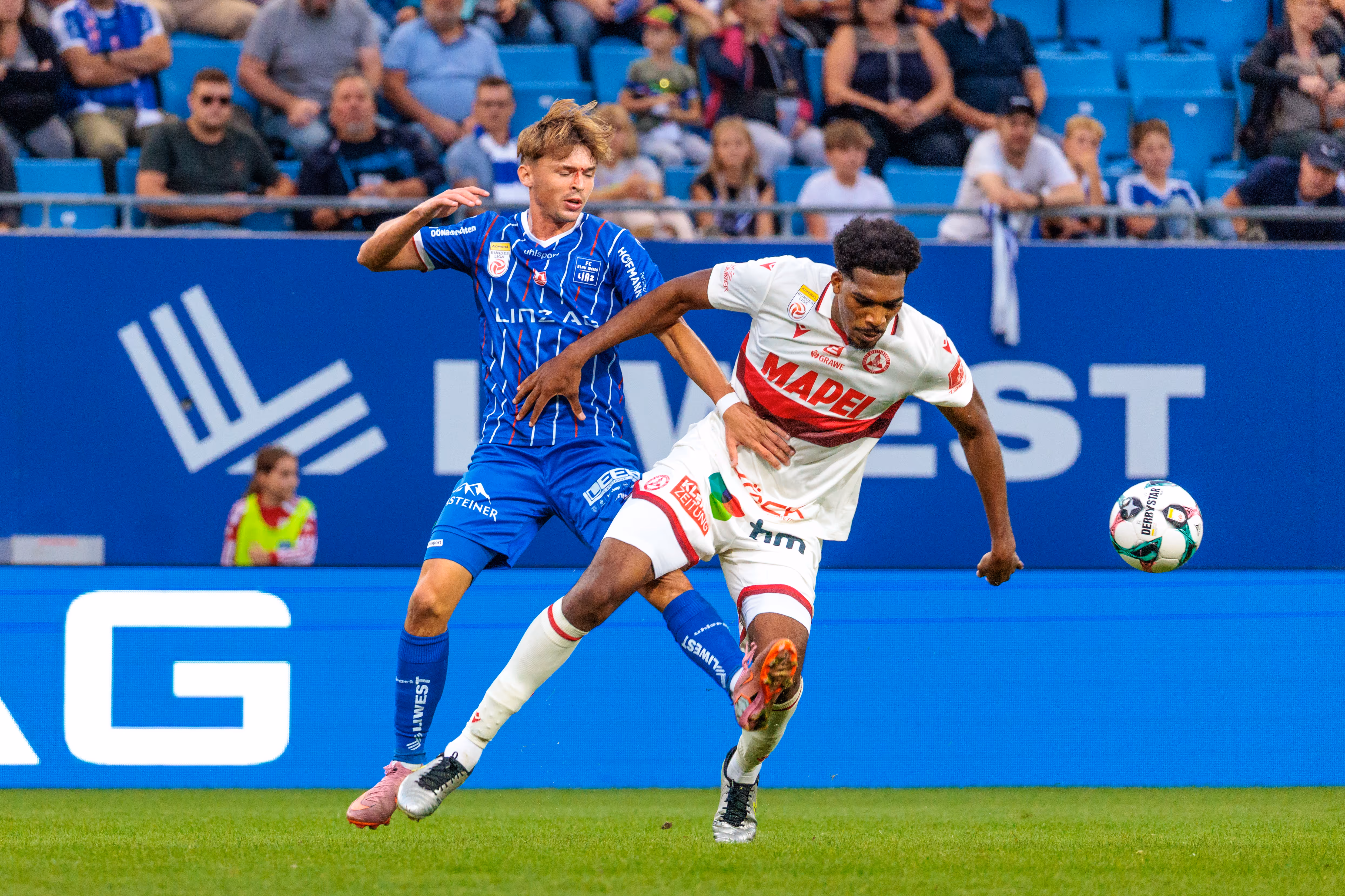 Der Blau-Weiß Linz Spieler Simon Seidl kämpft in einem intensiven Zweikampf gegen Sadik Fofana vom GAK