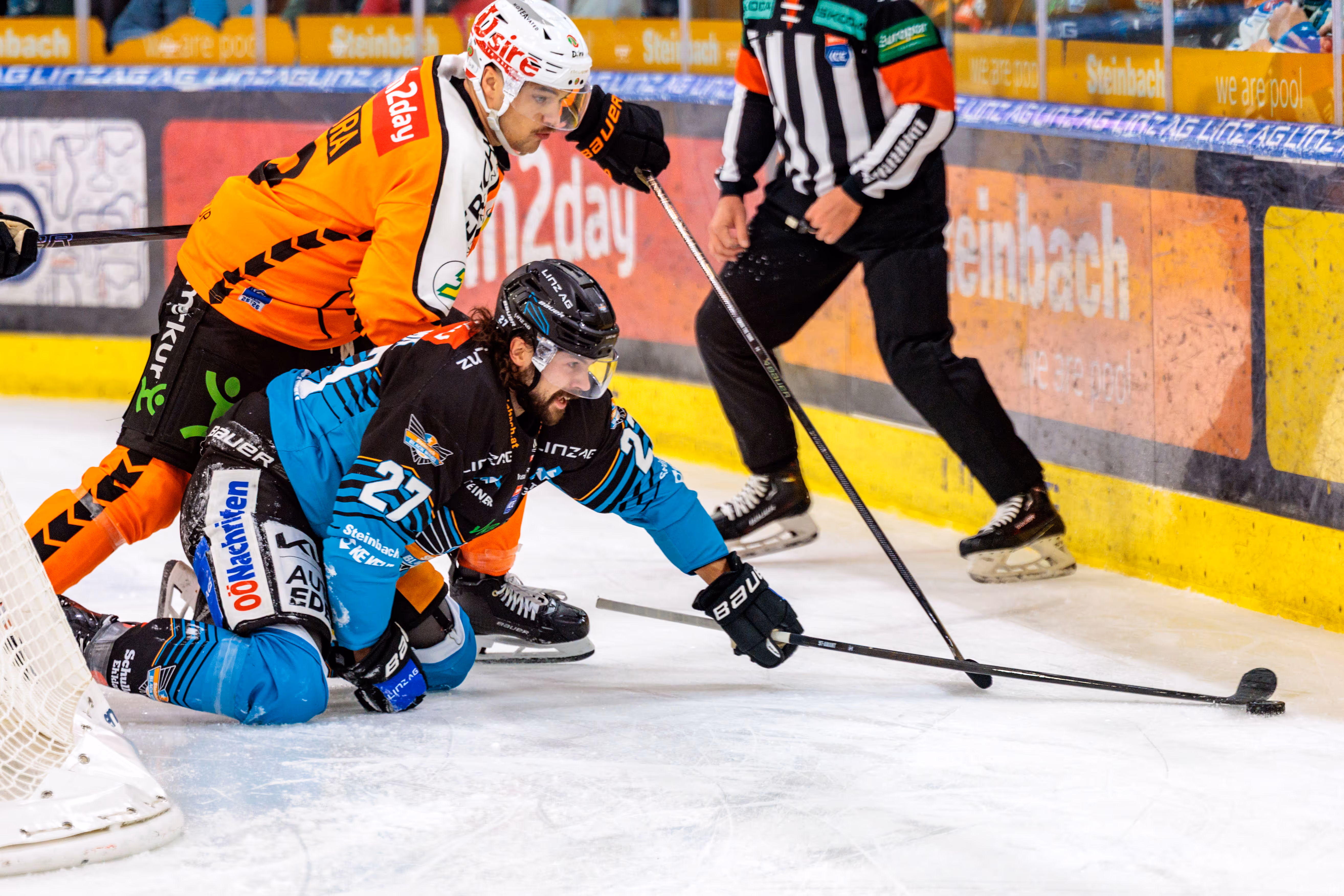 Der Eishockeyspieler Shawn St-Amant von den Steinbach Black Wings Linz kämpft auf den Knien im Duell mit Kevin Roy von den Graz99ers um den Puck