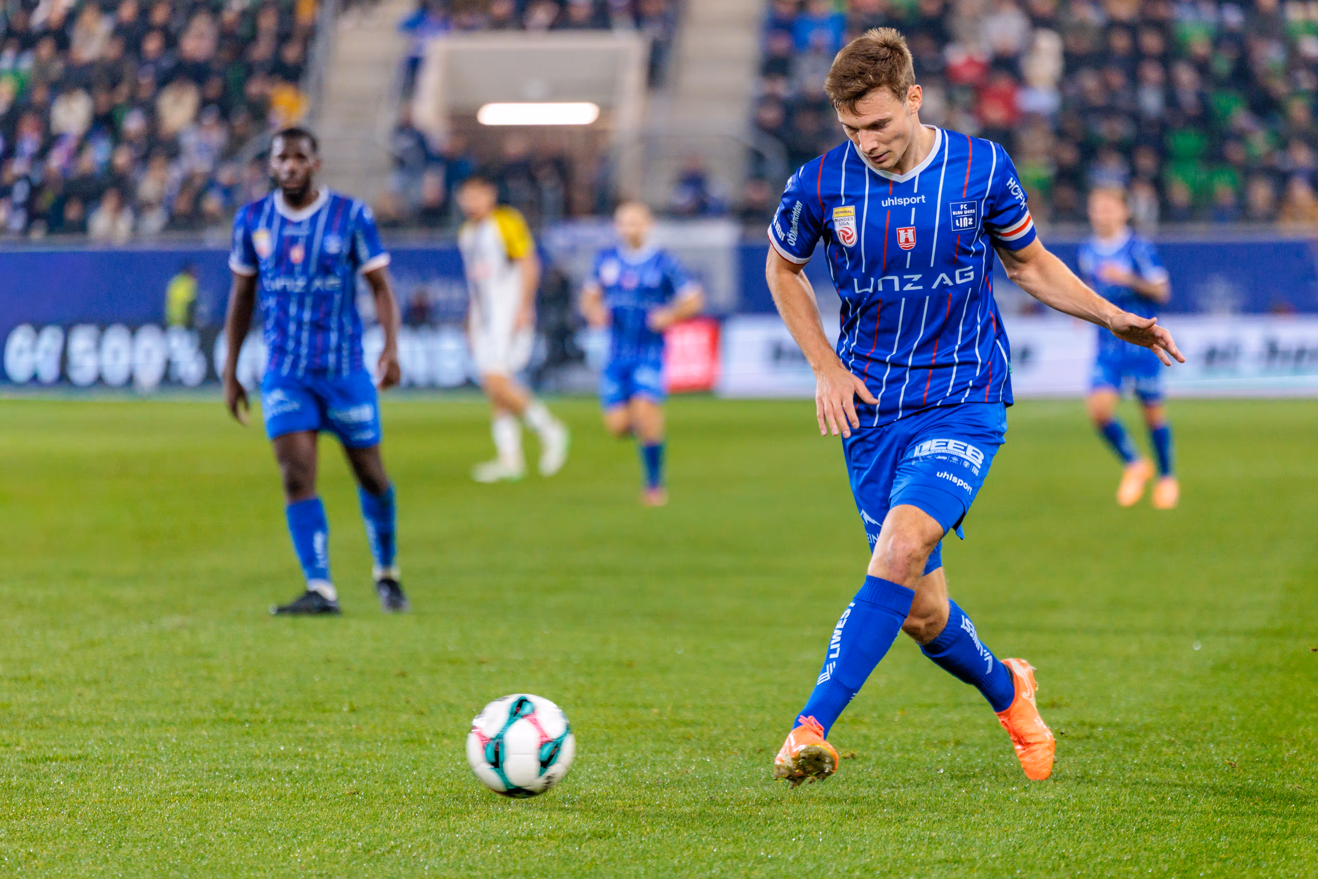 Der Fußballspieler Simon Seidl von Blau-Weiß Linz dribbelt während des Linzer Derbys konzentriert mit dem Ball