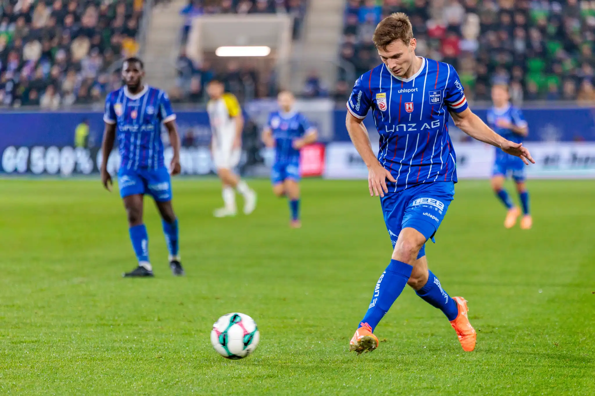 Der Fußballspieler Simon Seidl von Blau-Weiß Linz dribbelt während des Linzer Derbys konzentriert mit dem Ball