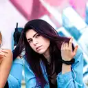 Eine junge Frau mit dunklem Haar und lila Strähnen trägt eine Jeansjacke und blickt vor einer farbigen Graffiti-Wand in die Kamera  lens: 56mm F1.4 DC DN | Contemporary 018