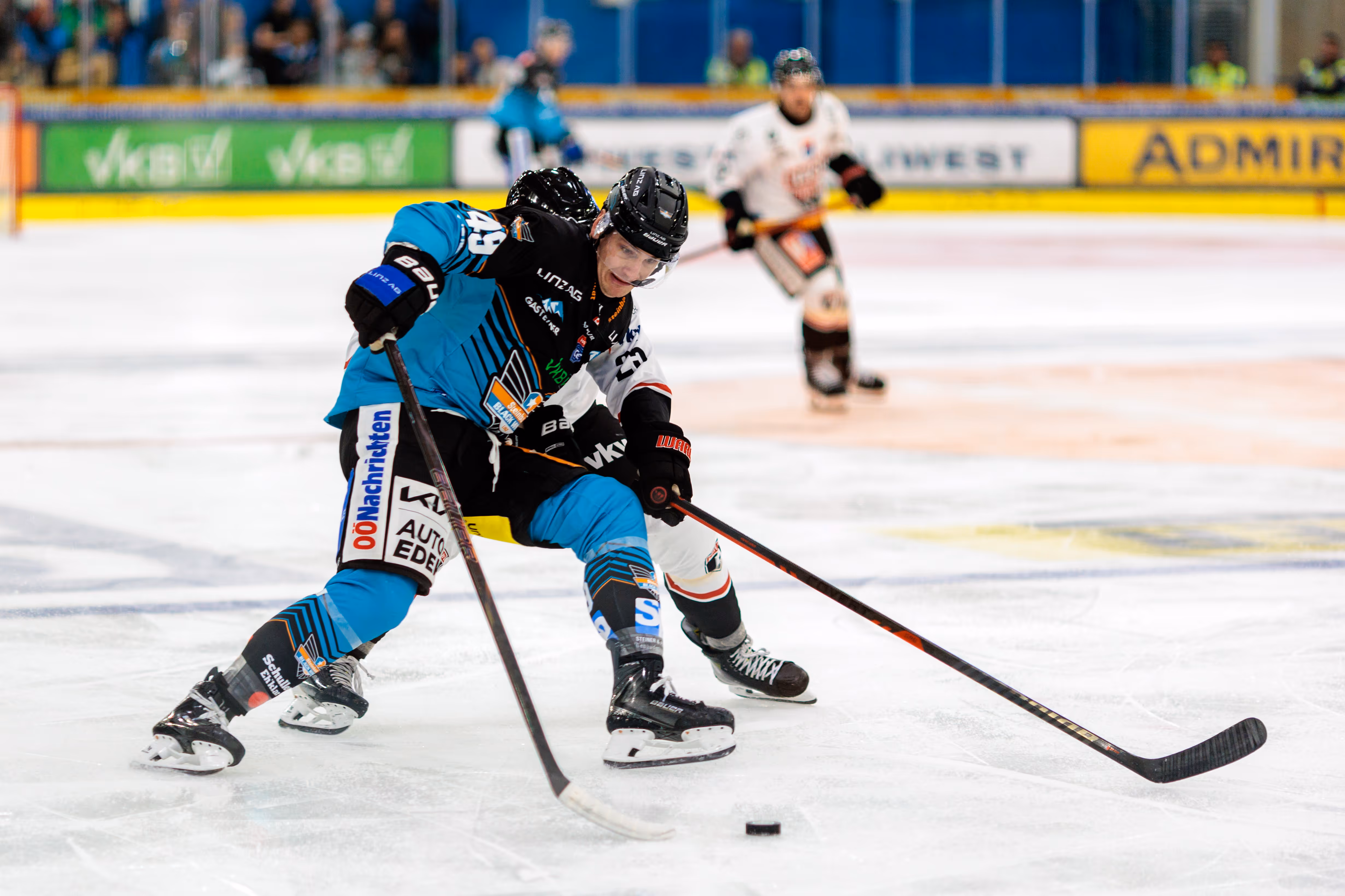 Eishockeyspieler Patrick Söllinger von den Steinbach Black Wings Linz im Zweikampf um den Puck auf dem Eis während eines Spiels