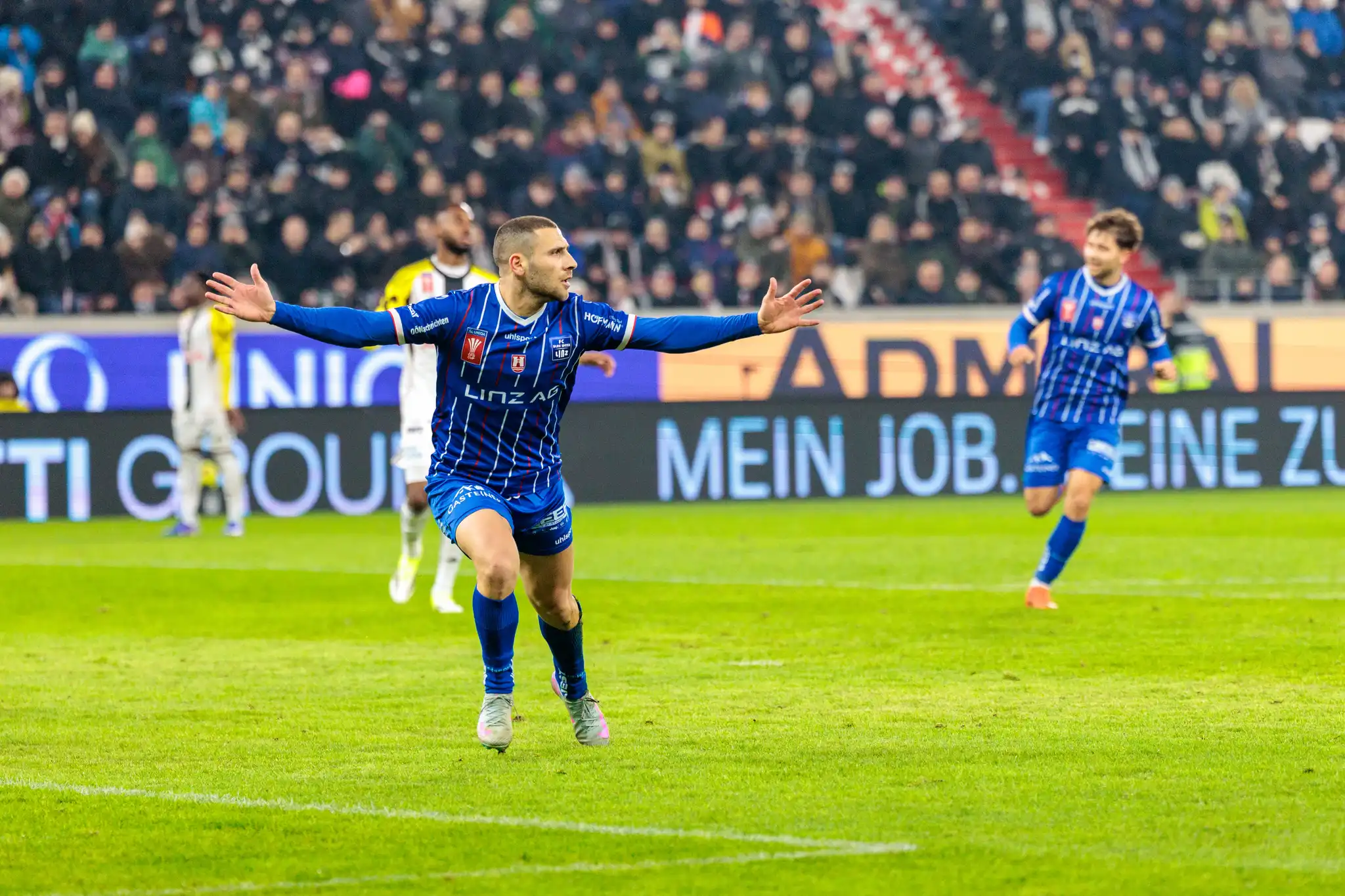 Stürmer Shon Weissman vom FC Blau-Weiß Linz bejubelt mit ausgebreiteten Armen seinen Treffer im emotionalen Linzer Derby des ÖFB Cups gegen den LASK