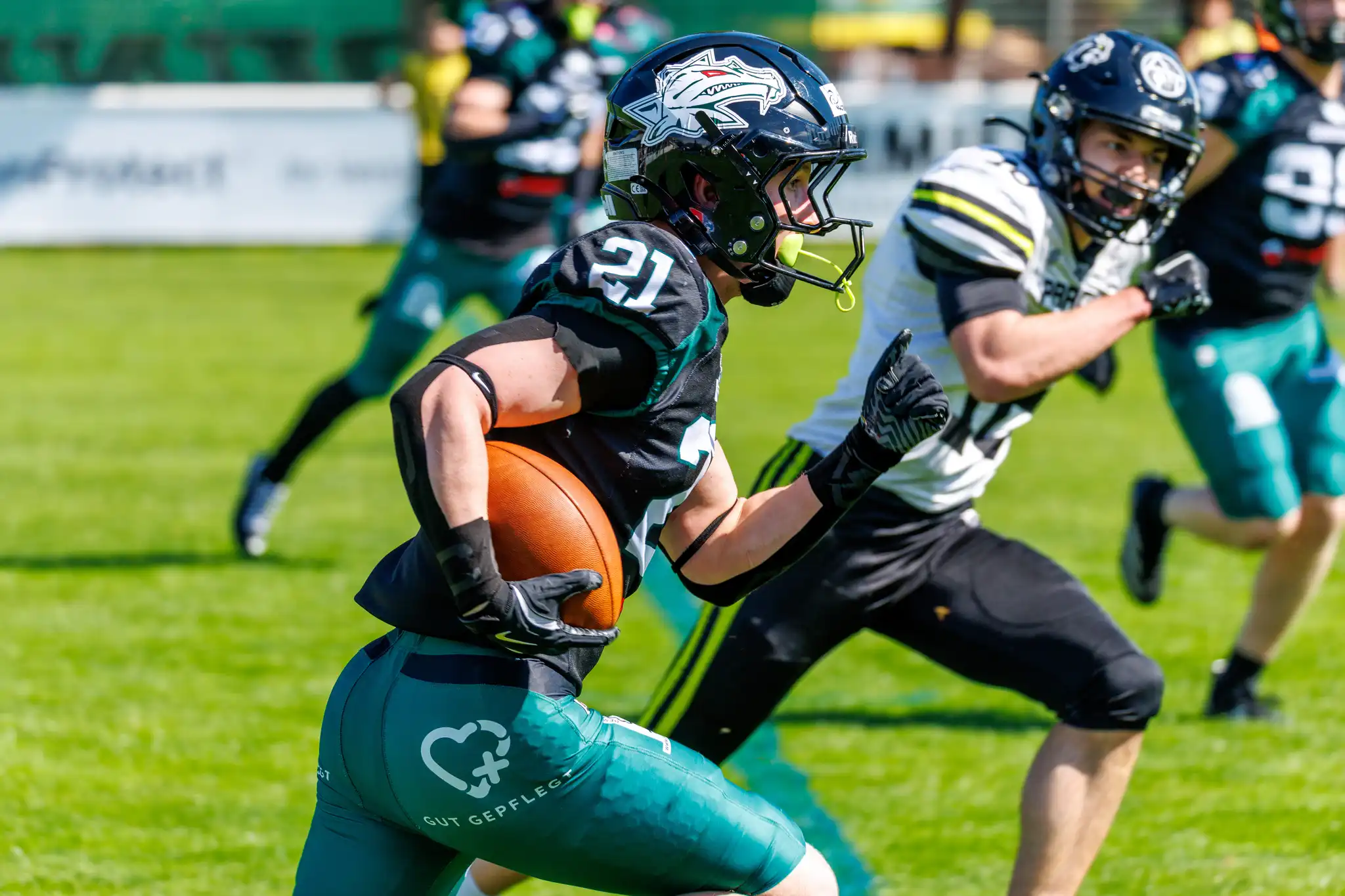 Ein American Football Spieler der Danube Dragons läuft mit dem Ball vor einem verfolgenden Spieler der Prague Black Panthers