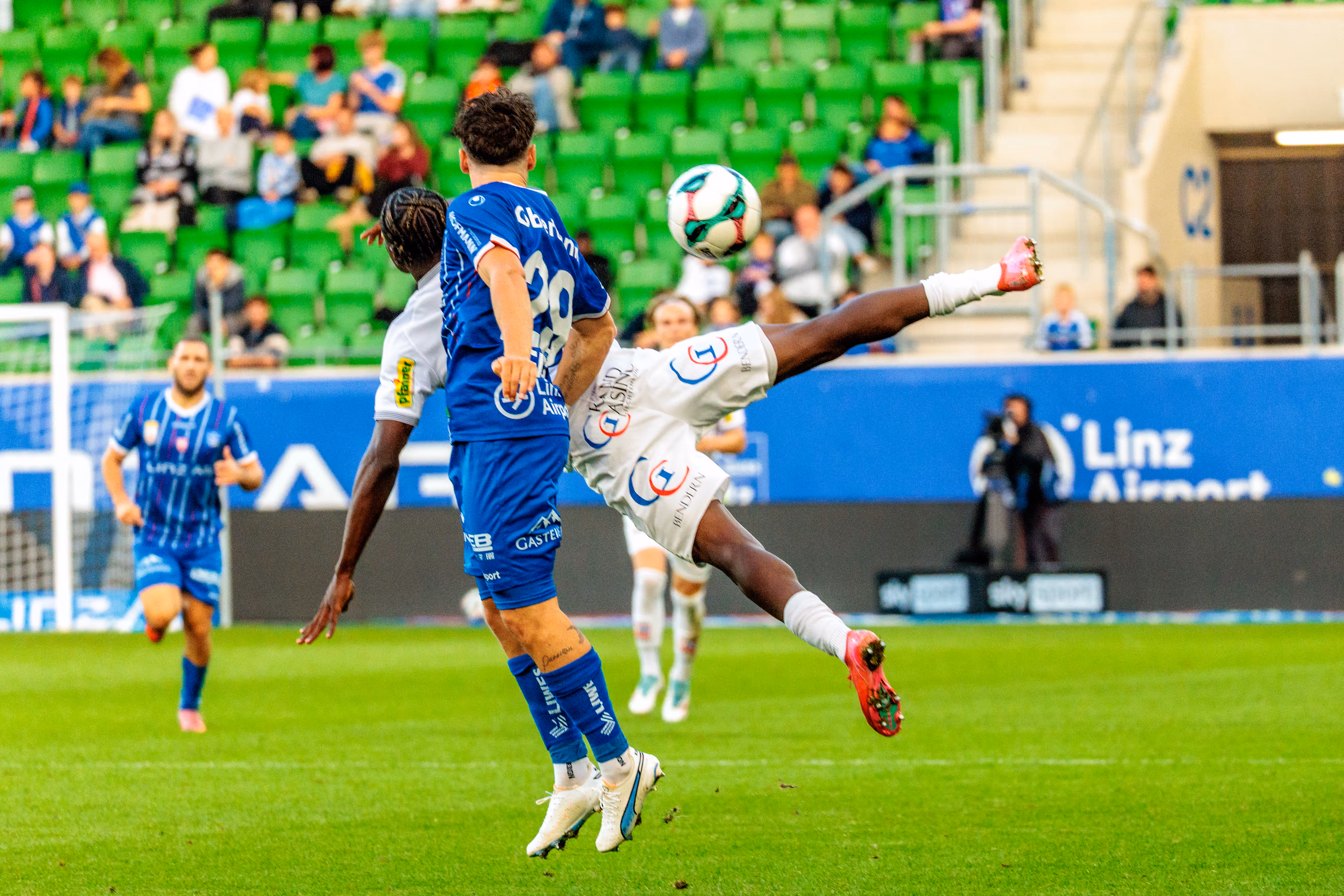 Der Stürmer des SCR Altach, Srdjan Hrstic, versucht mit einem akrobatischen Tritt in der Luft den Ball vor einem Gegenspieler von Blau-Weiß Linz zu erreichen