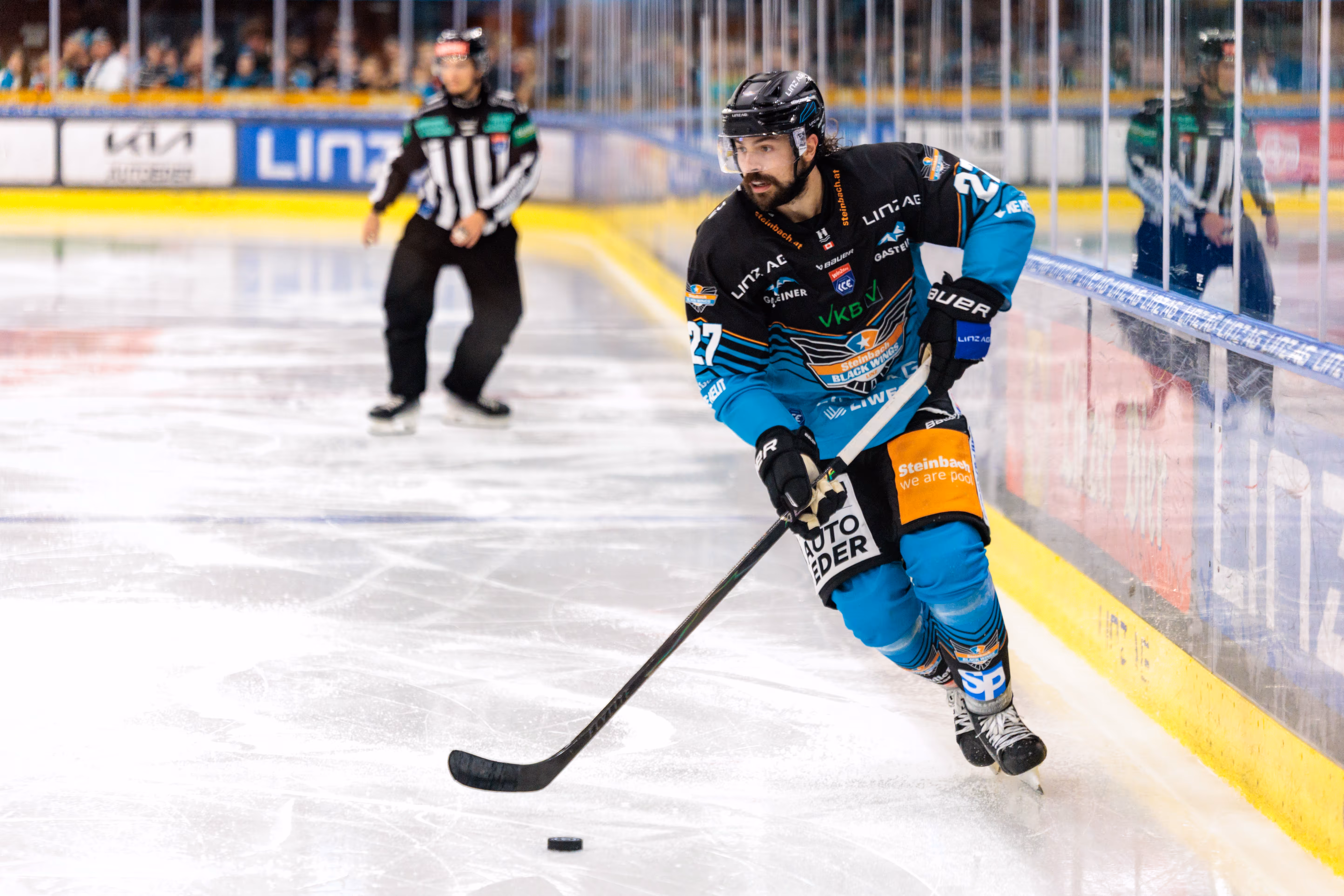 Eishockeyspieler Shawn St-Amant von den Black Wings Linz dribbelt den Puck auf dem Eis während eines Spiels