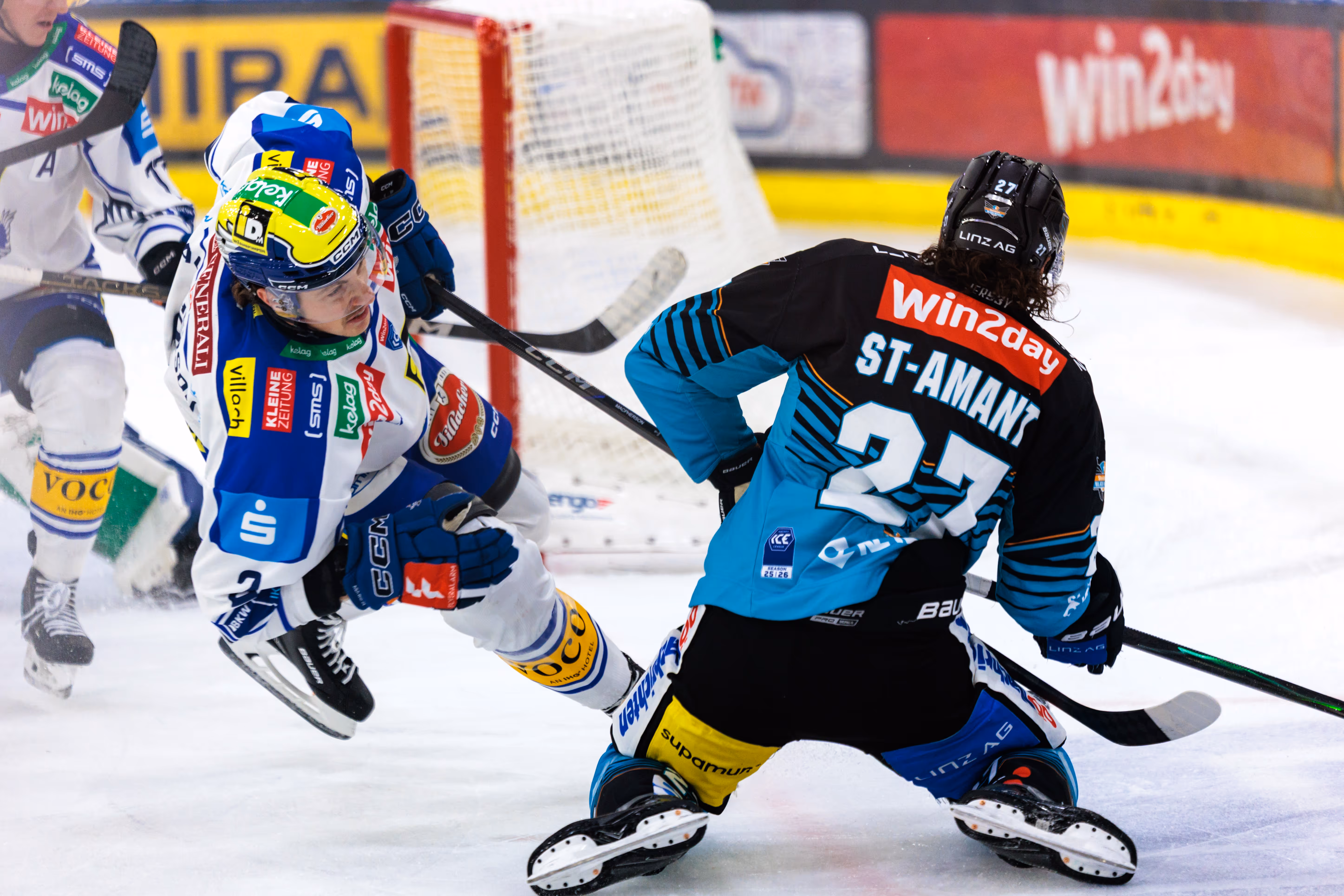 Der Eishockeyspieler Shawn St-Amant mit der Nummer 27 von Black Wings Linz schießt aufs Tor, während ein Spieler des EC VSV auf dem Eis blockiert