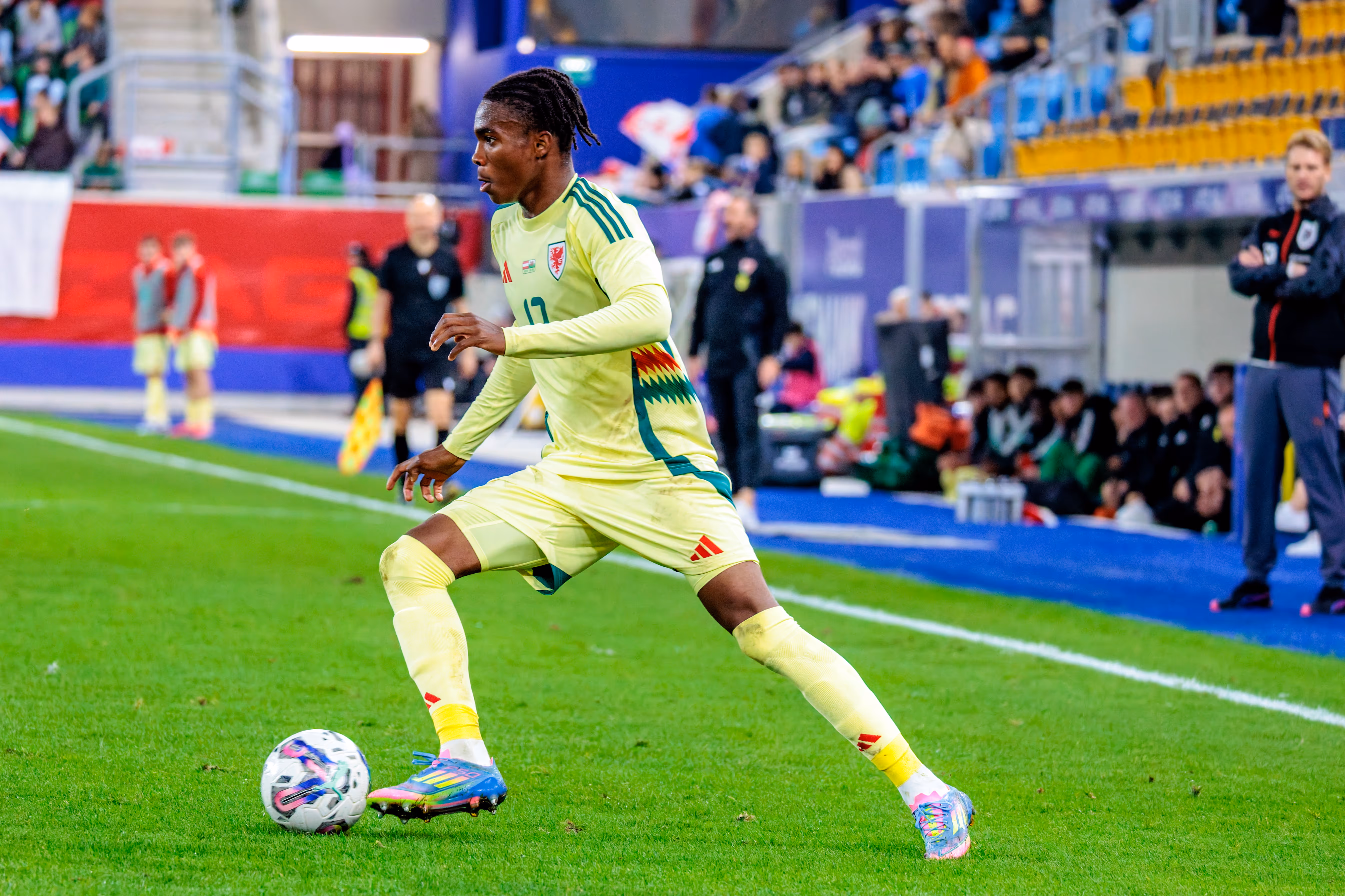 Der walisische U21-Nationalspieler Tanatswa Nyakuhwa führt im gelben Auswärtsdress konzentriert den Ball während des EM-Qualifikationsspiels gegen Österreich