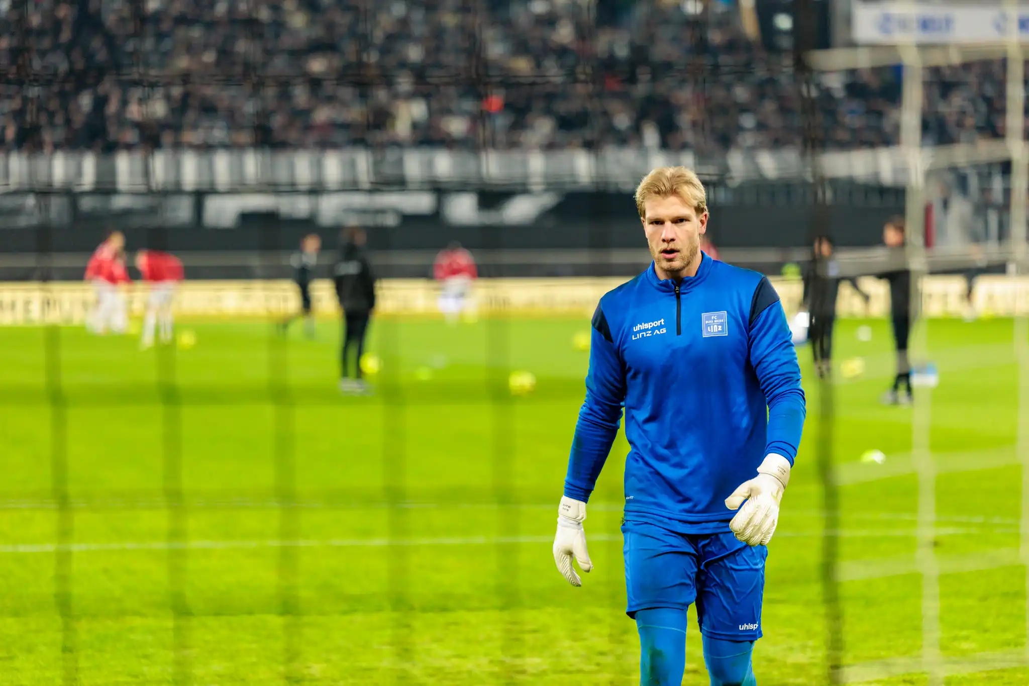 Blau-Weiß Linz Torhüter Nico Mantl blickt konzentriert mit weißen Torwarthandschuhen beim Linzer Derby im ÖFB-Cup gegen den LASK