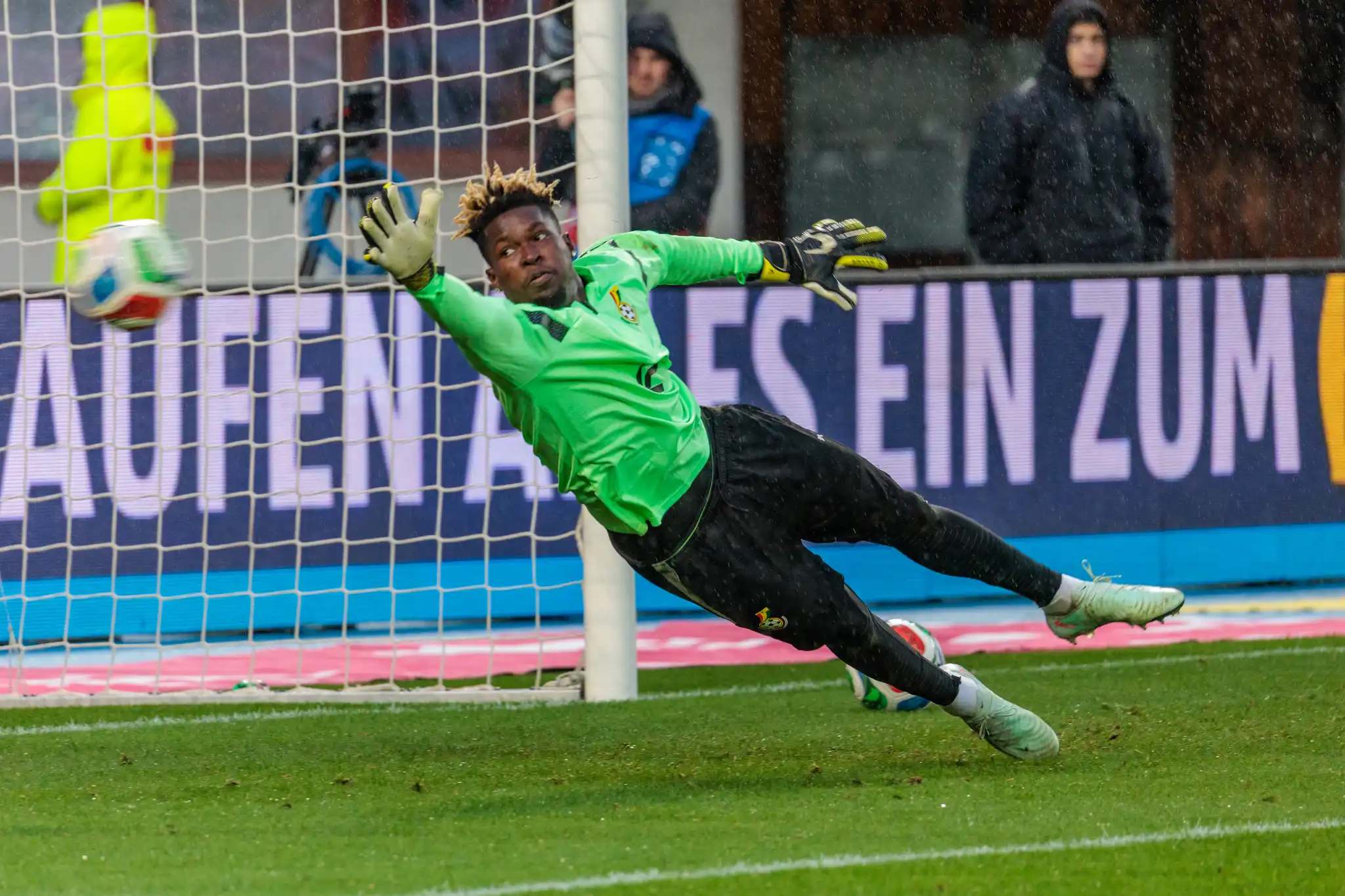 Der ghanaische Torwart Lawrence Ati Zigi in einem hellgrünen Trikot hechtet im WM-Testspiel Österreich gegen Ghana nach einem Fußball in Richtung Tornetz