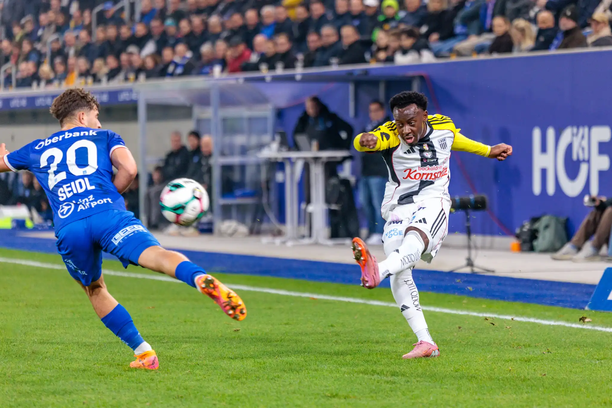LASK-Angreifer Moses Usor zieht im Linzer Derby kraftvoll ab, während Simon Seidl von Blau-Weiß Linz versucht, den Torschuss zu blocken