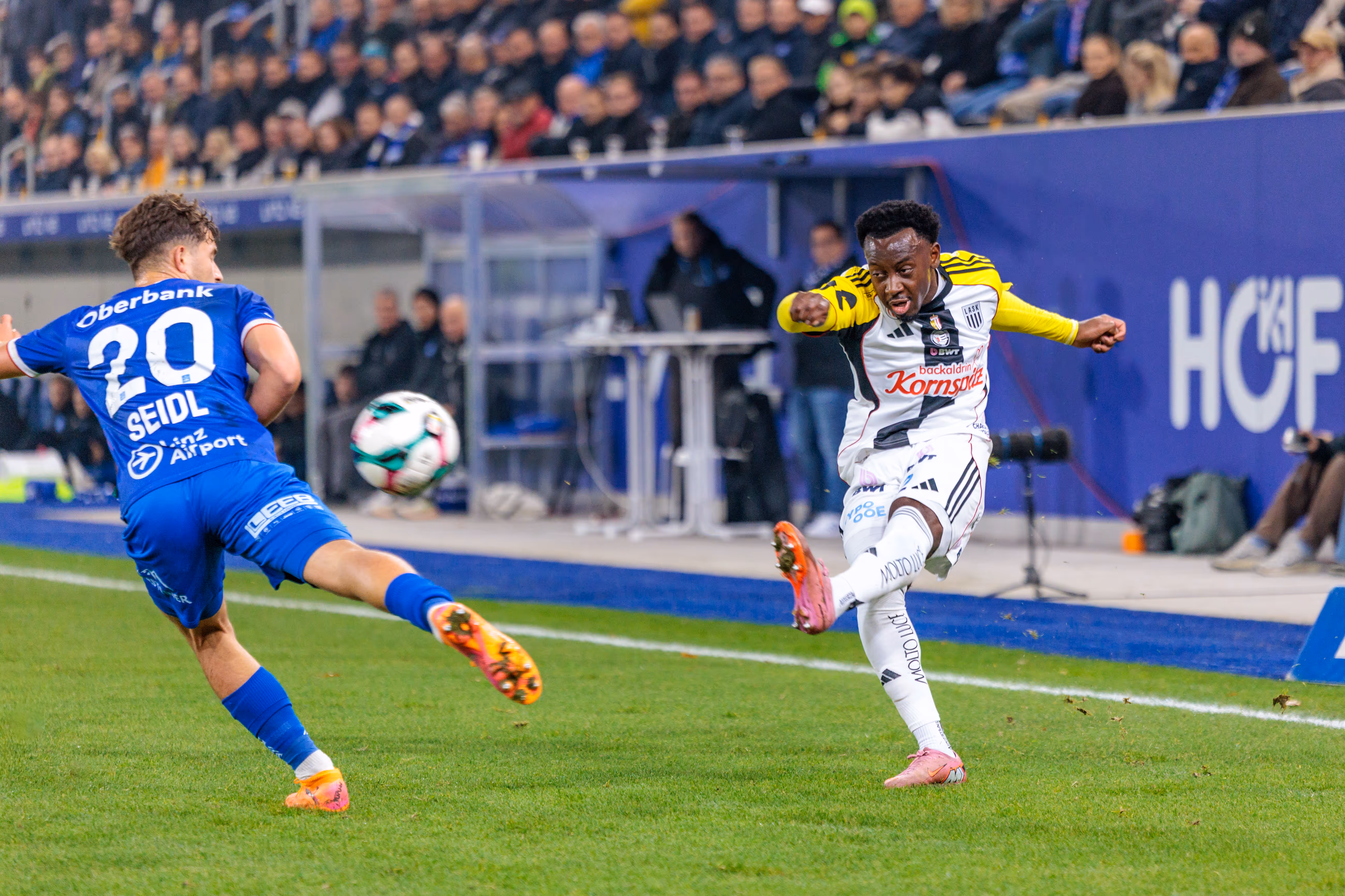 LASK-Angreifer Moses Usor zieht im Linzer Derby kraftvoll ab, während Simon Seidl von Blau-Weiß Linz versucht, den Torschuss zu blocken