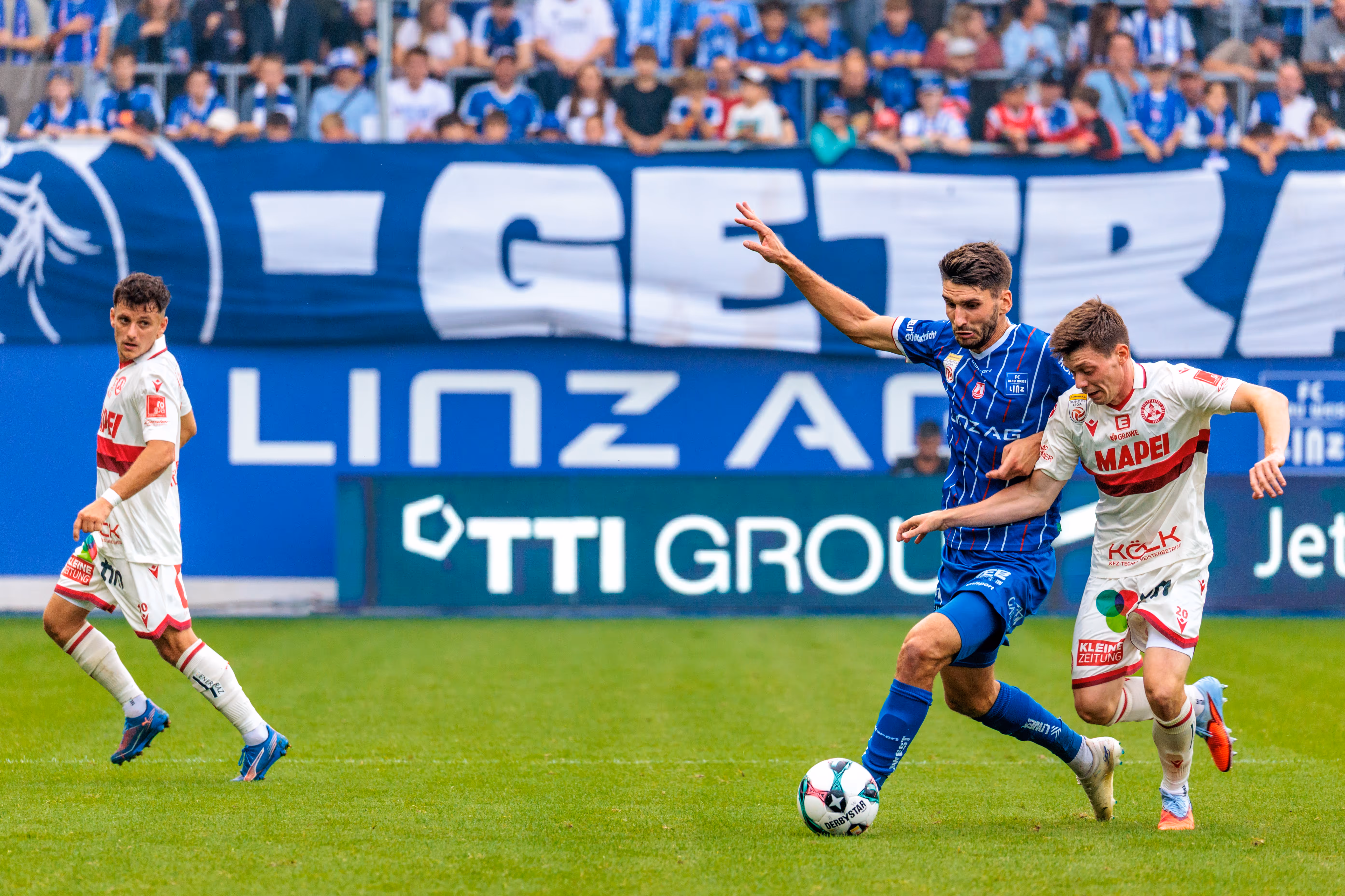 Der Stürmer von Blau-Weiß Linz, Shon Weissman, dribbelt mit dem Ball und wird im Zweikampf von Thorsten Schriebl vom GAK bedrängt